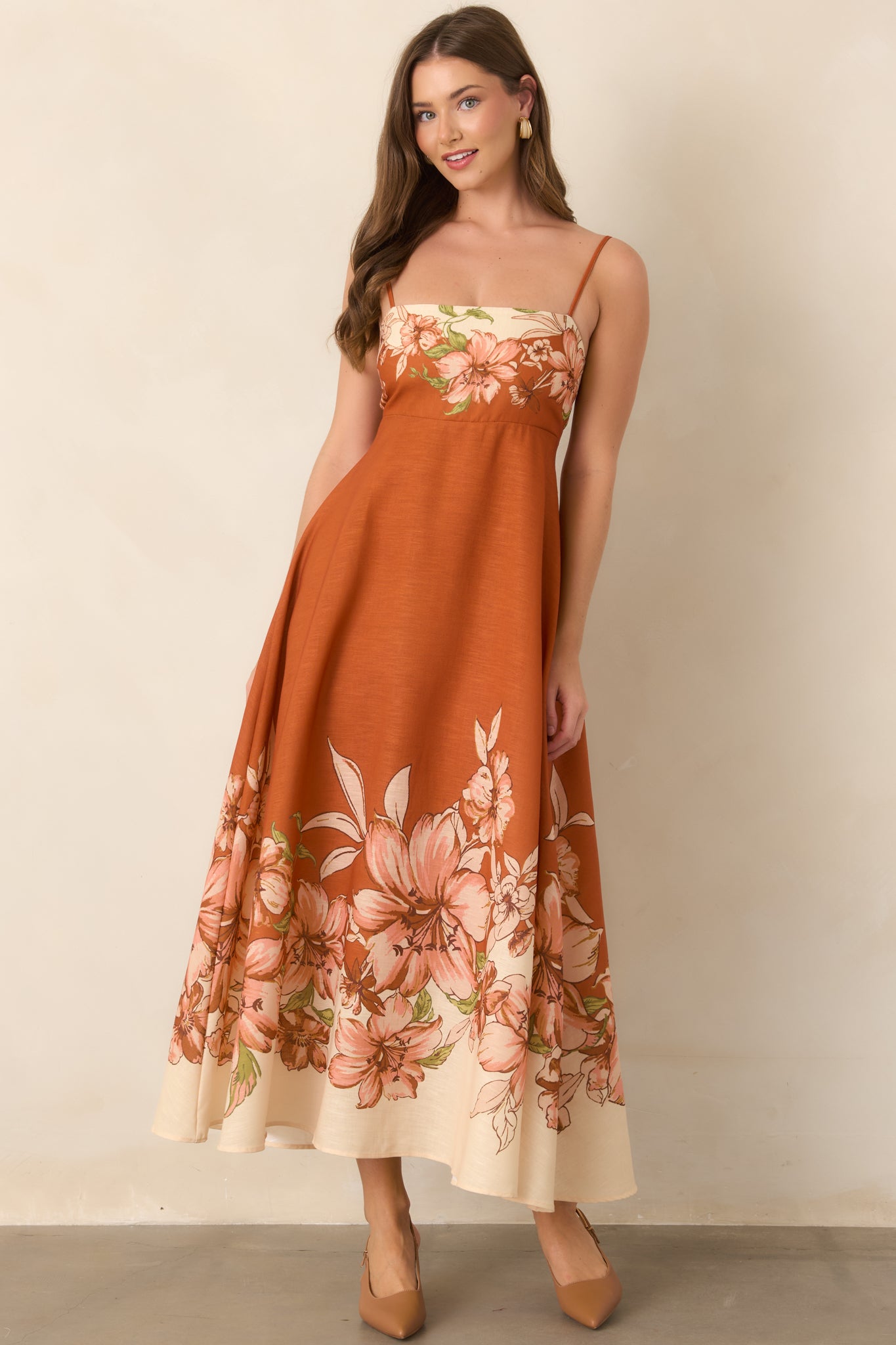 Floral-print dress with a fitted bodice, delicate adjustable straps, and an elongated flowing skirt.