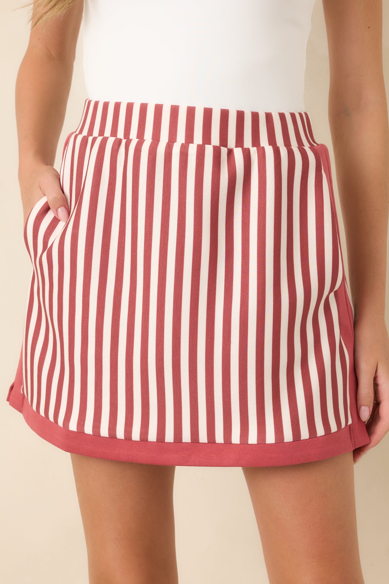 Close-up of the terracotta and ivory striped fabric with contrast terracotta trim, highlighting the texture and clean construction of the skirt.