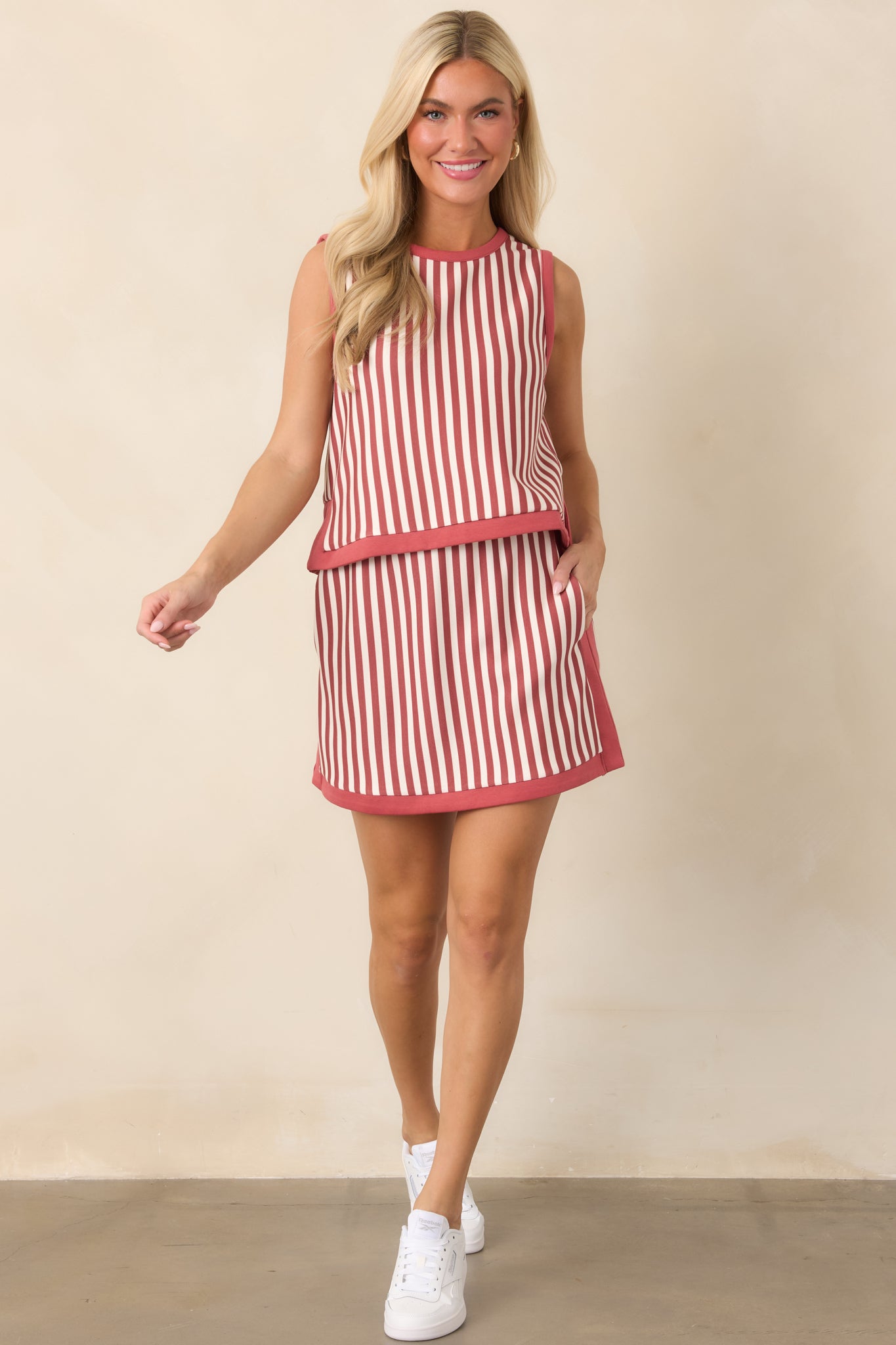 Terracotta and ivory striped sleeveless top with a round neckline, contrast terracotta trim, and relaxed cropped silhouette.