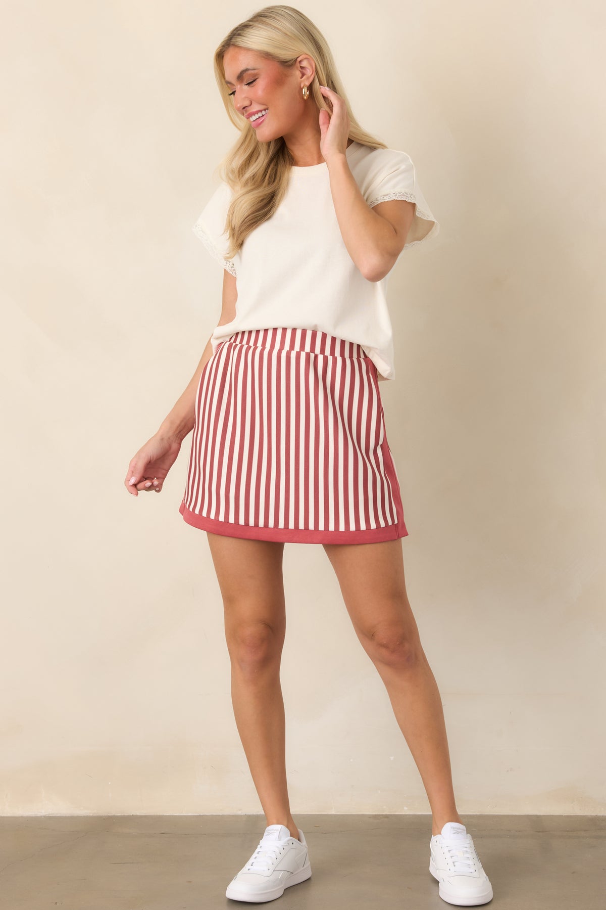 Terracotta and ivory vertical-striped skort featuring a defined high-rise waist, contrast trim, side pockets, and a fluid skirt overlay.