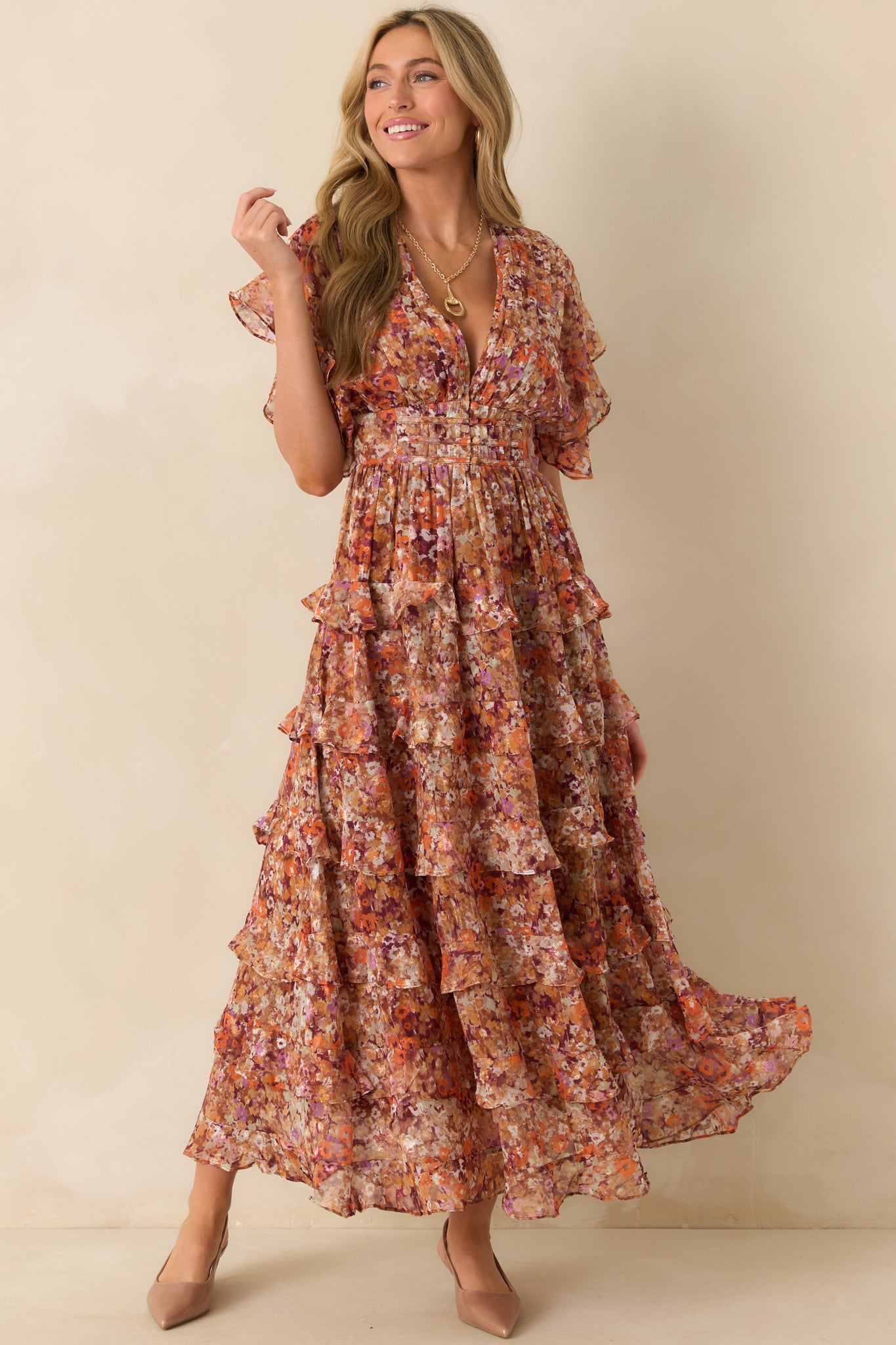 Terracotta maxi dress with multi floral print, deep V-neckline, and short flutter sleeves.