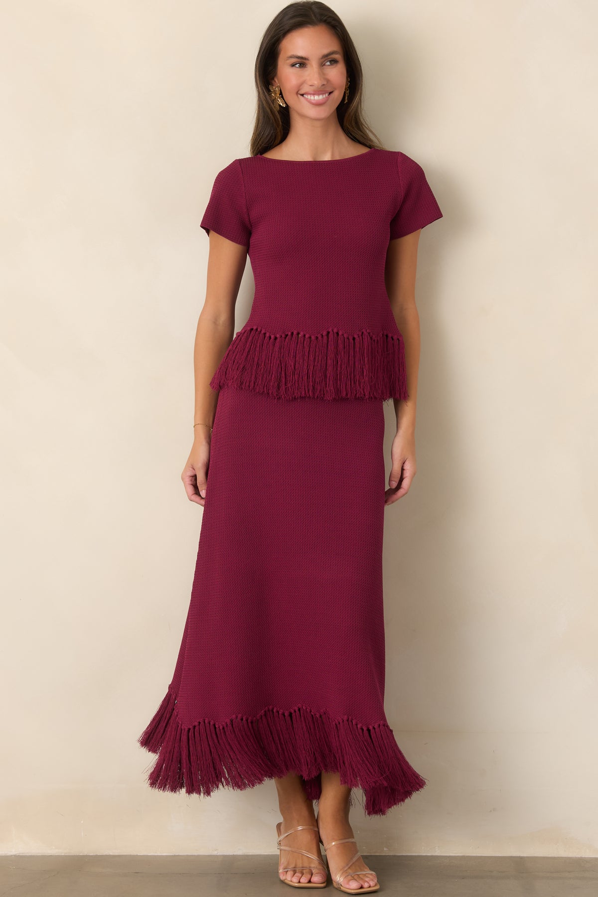 Textured berry skirt with a clean elongated silhouette and softly moving fringe at the hem.