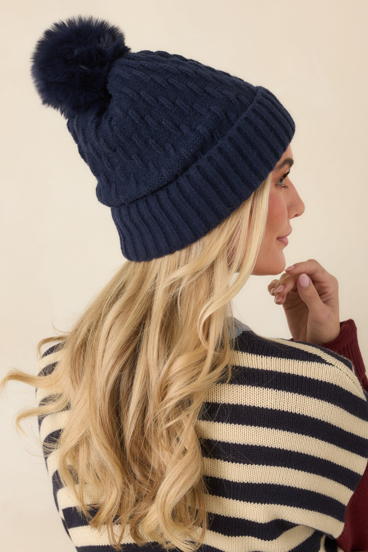 Textured cable-knit hat showcases a soft matching pom and a wide ribbed cuff with a slightly slouchy silhouette.