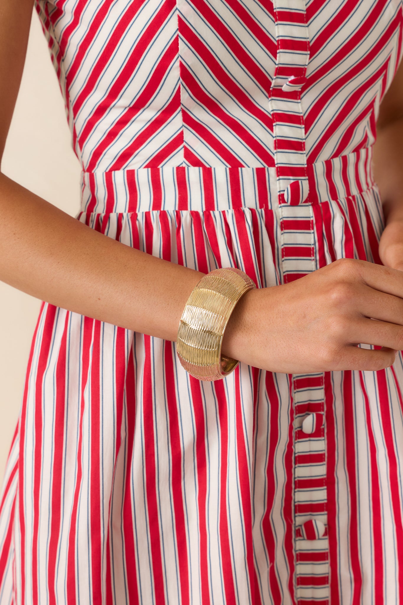 Statement gold bracelet showcasing dimensional texture, sleek hardware details, and a structured silhouette.