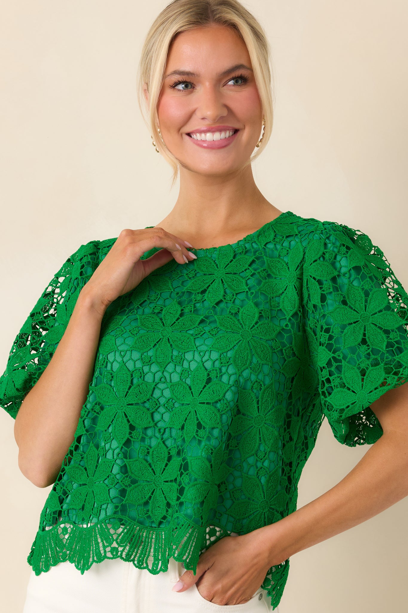 Textured green lace fabric with floral design and soft inner lining.