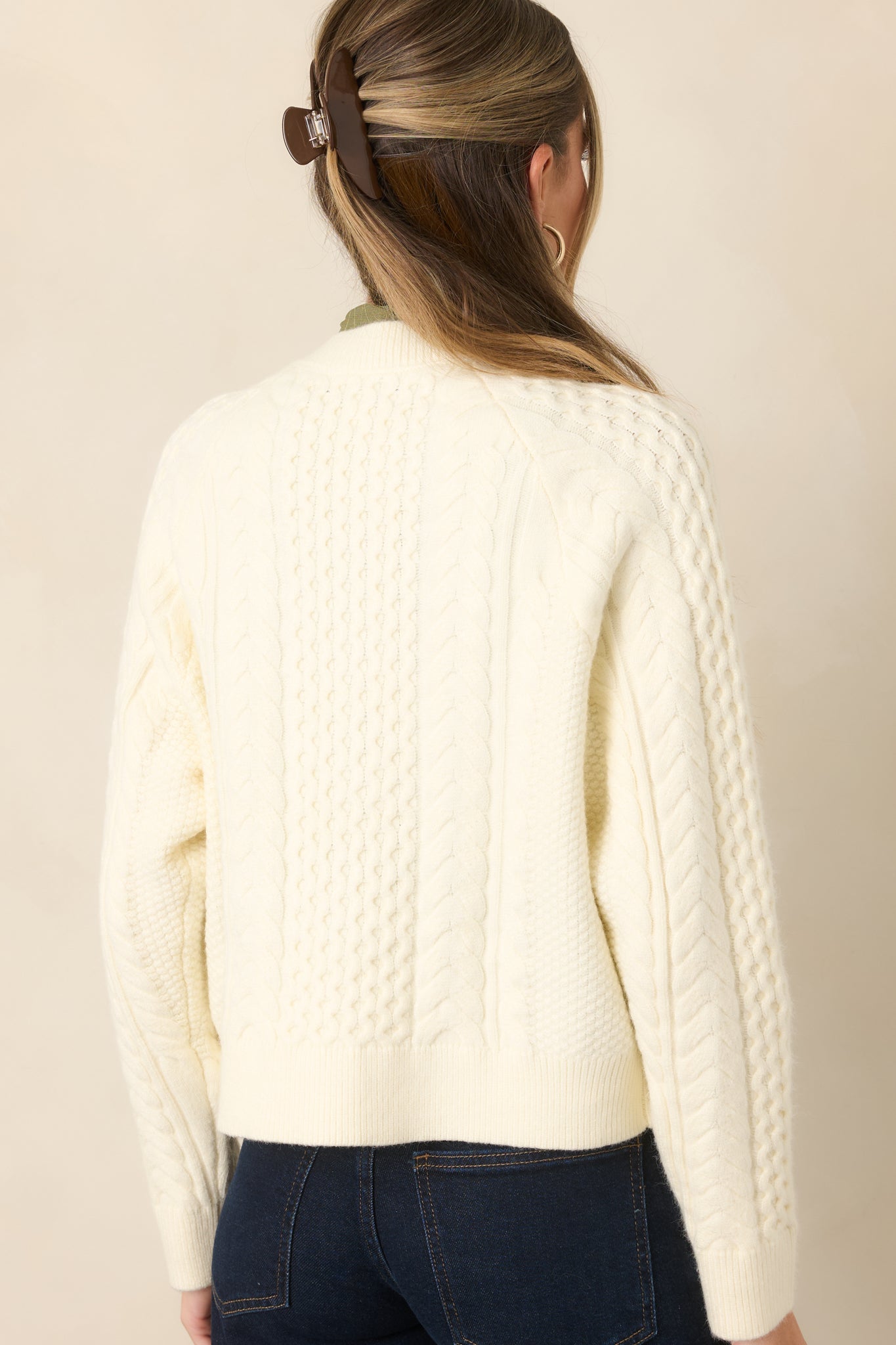 Rear view of the textured knit cardigan showcasing mixed stitching, long sleeves, and ribbed trim along the neckline and hem.