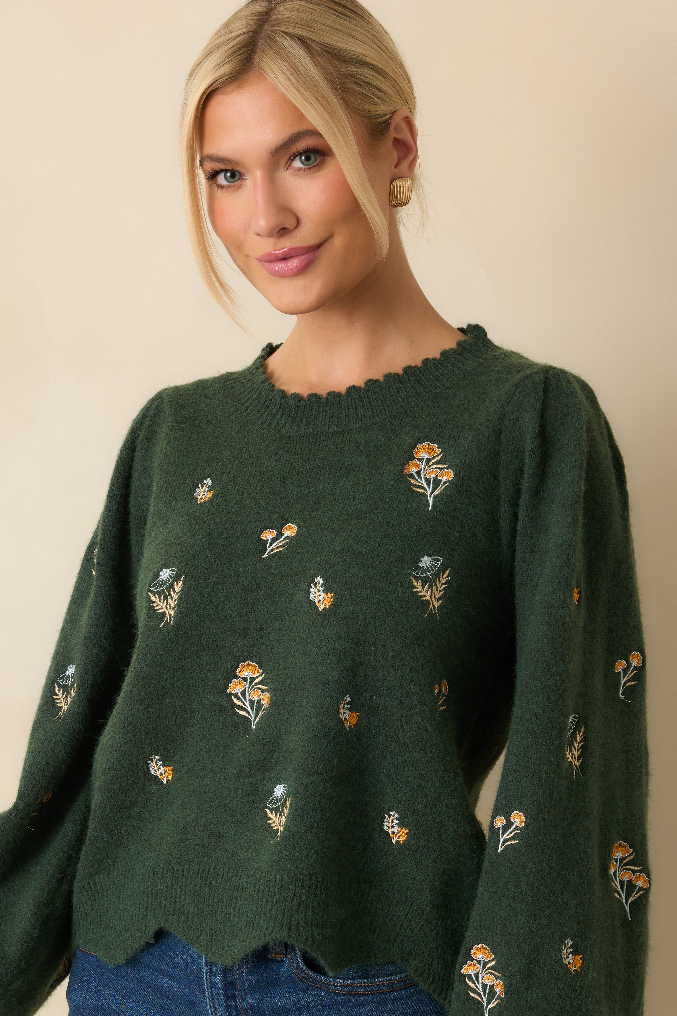 Detailed look at the textured knit and embroidery across the front of the sweater.