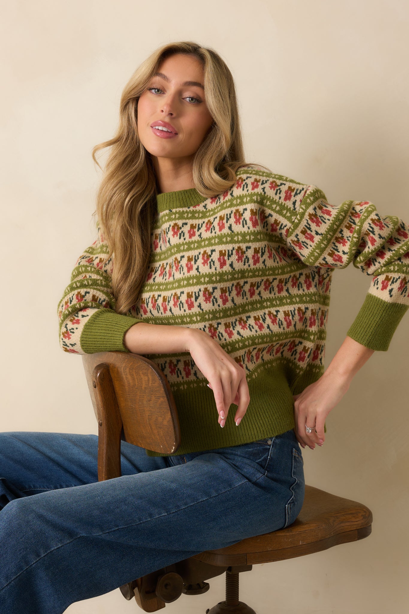Textured knit fabric of the olive green sweater with rust and ivory Fair Isle accents.