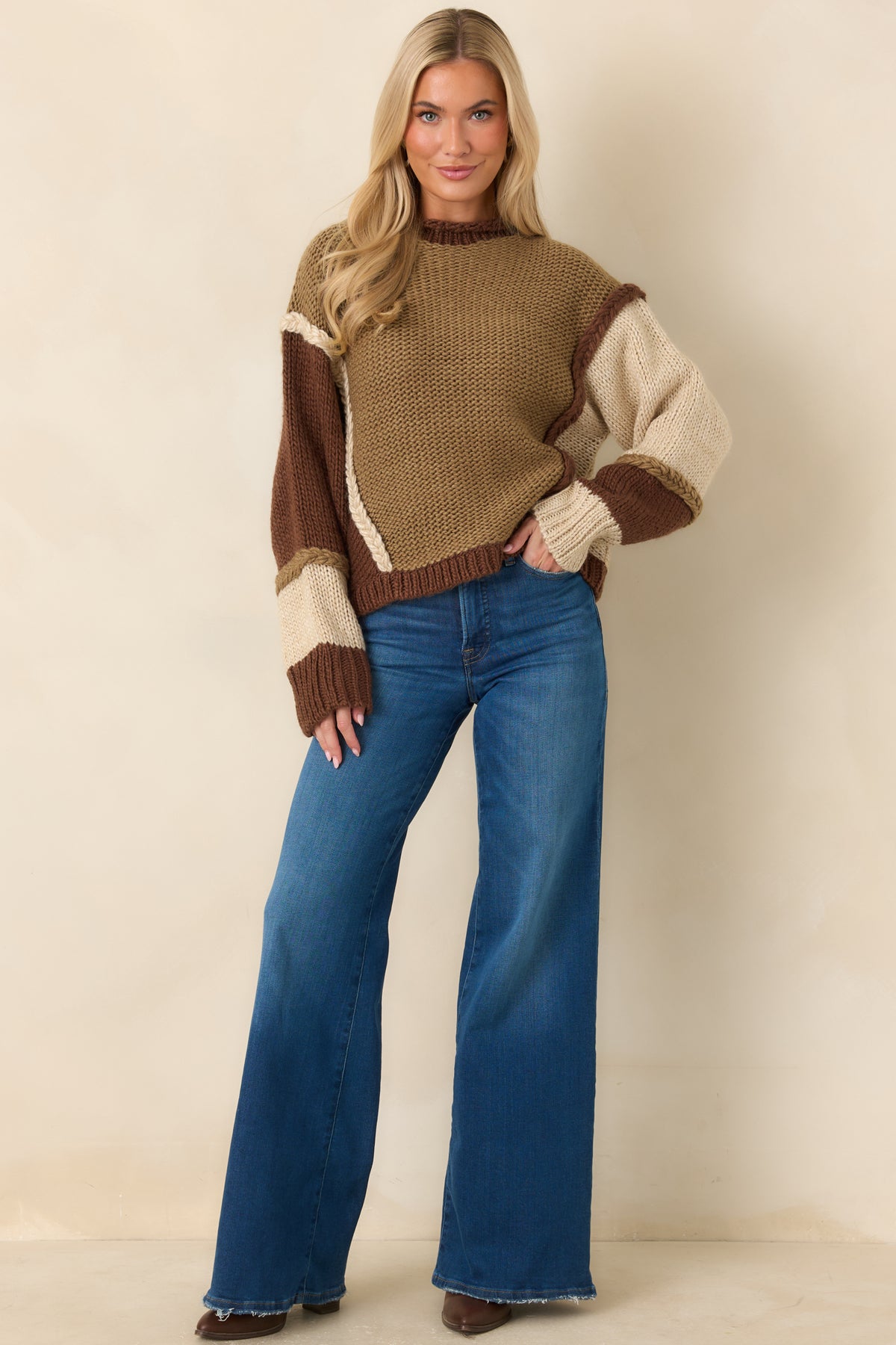 Textured knit top with raised braided detailing, chocolate brown ribbed cuffs, and a coordinating ribbed hem.