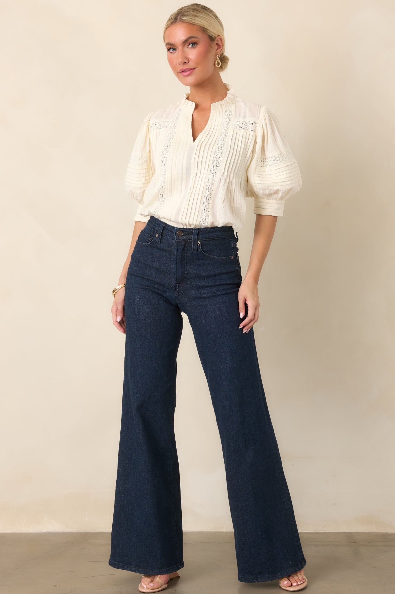 Textured blouse with an elegant mix of lace and pleated fabric, featuring a softly ruffled neckline and flowing three-quarter balloon sleeves.