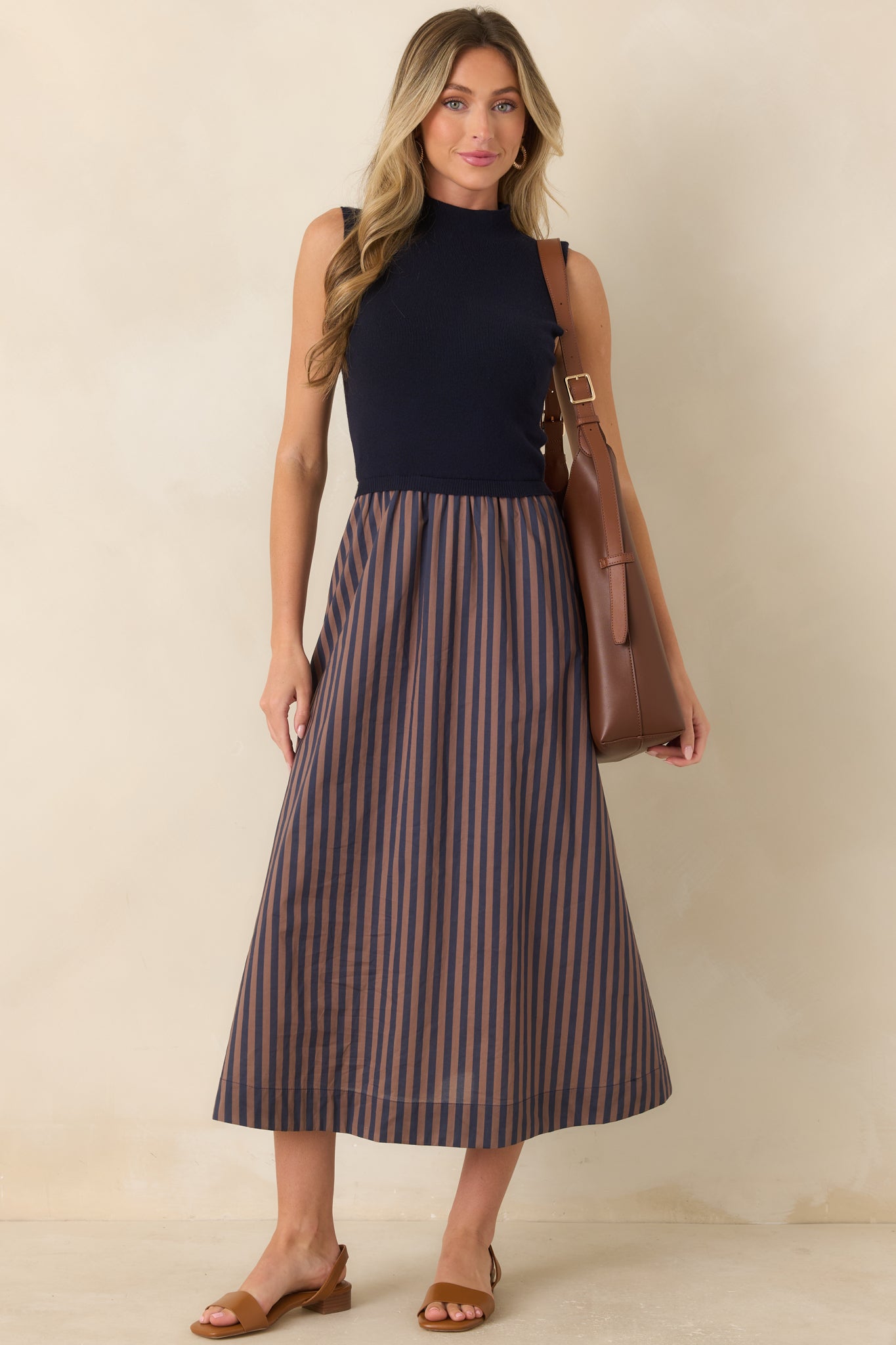 Textured midi dress featuring a fitted navy bodice and a full skirt accented with warm tan horizontal stripes.
