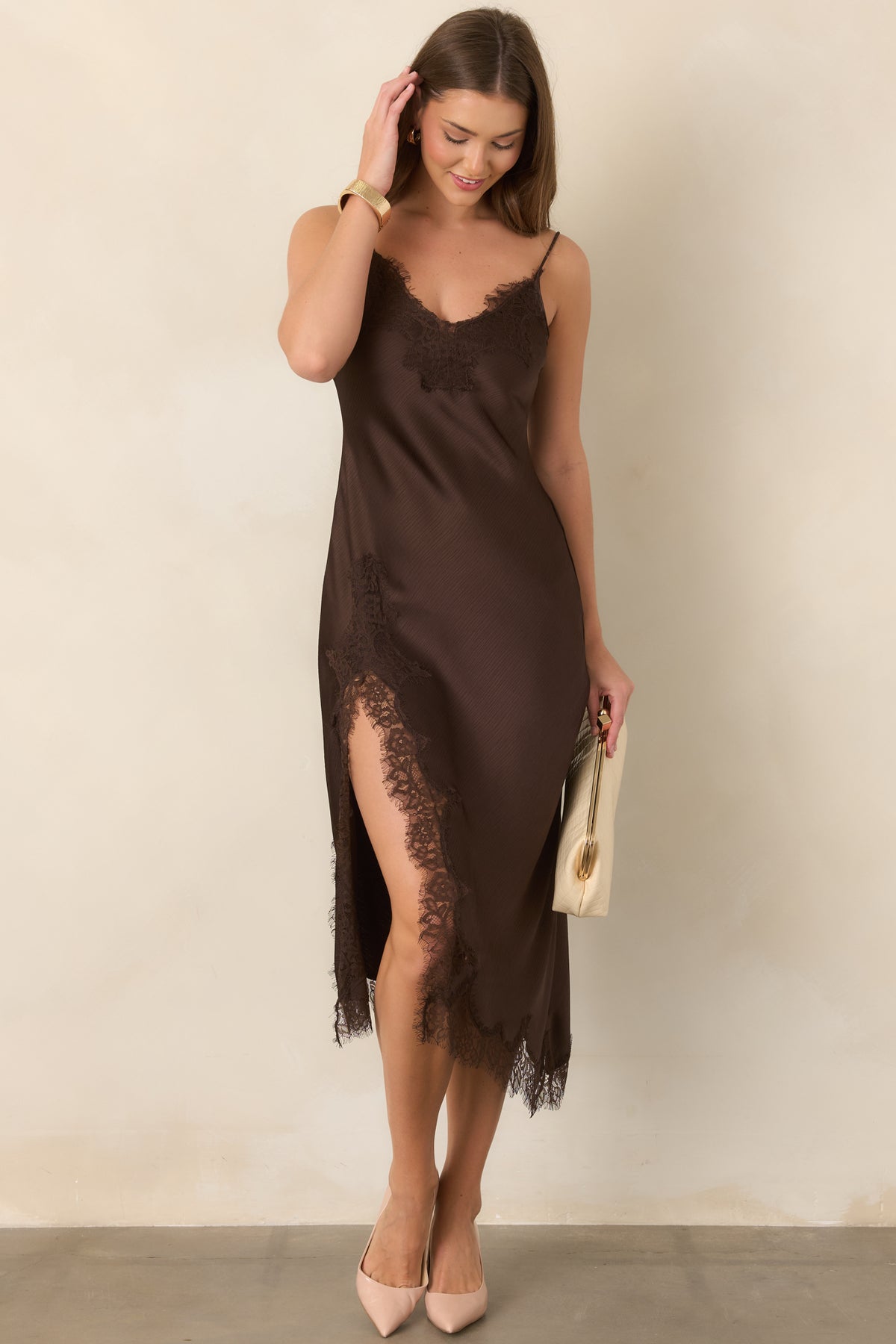 Textured satin bias-cut midi dress with delicate eyelash lace trim, adjustable spaghetti straps, a lace-accented side slit, and an elegantly uneven hemline.