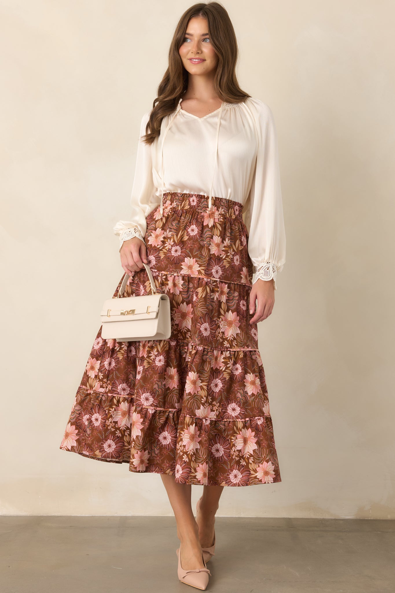 Lightly textured top featuring a smocked ruffle neckline, V-shaped opening, slender gold-accented ties, and voluminous balloon sleeves.
