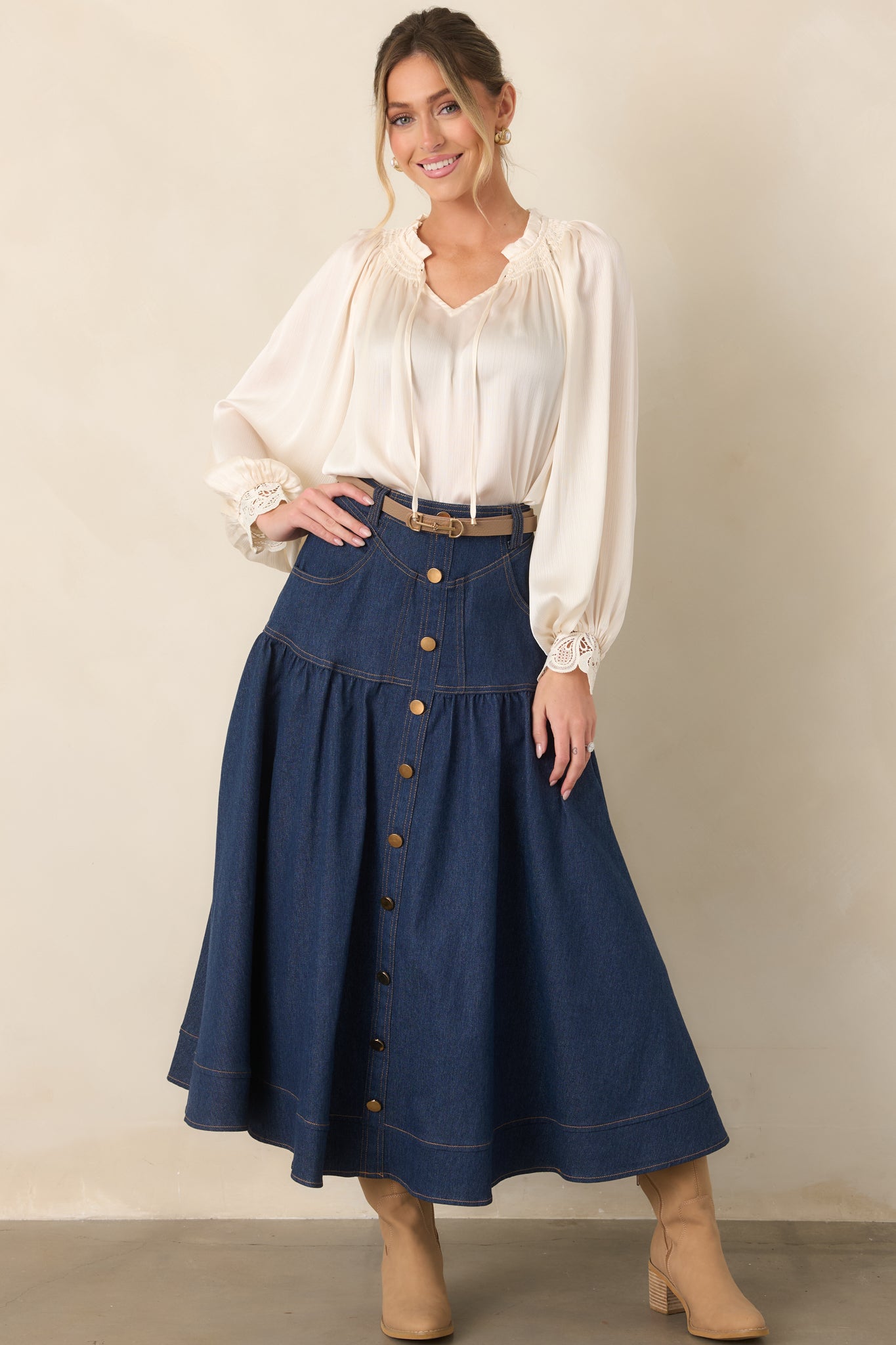 Textured top with a smocked ruffle neckline, V-shaped opening, slender tie accents, long balloon sleeves, and delicate lace cuffs.