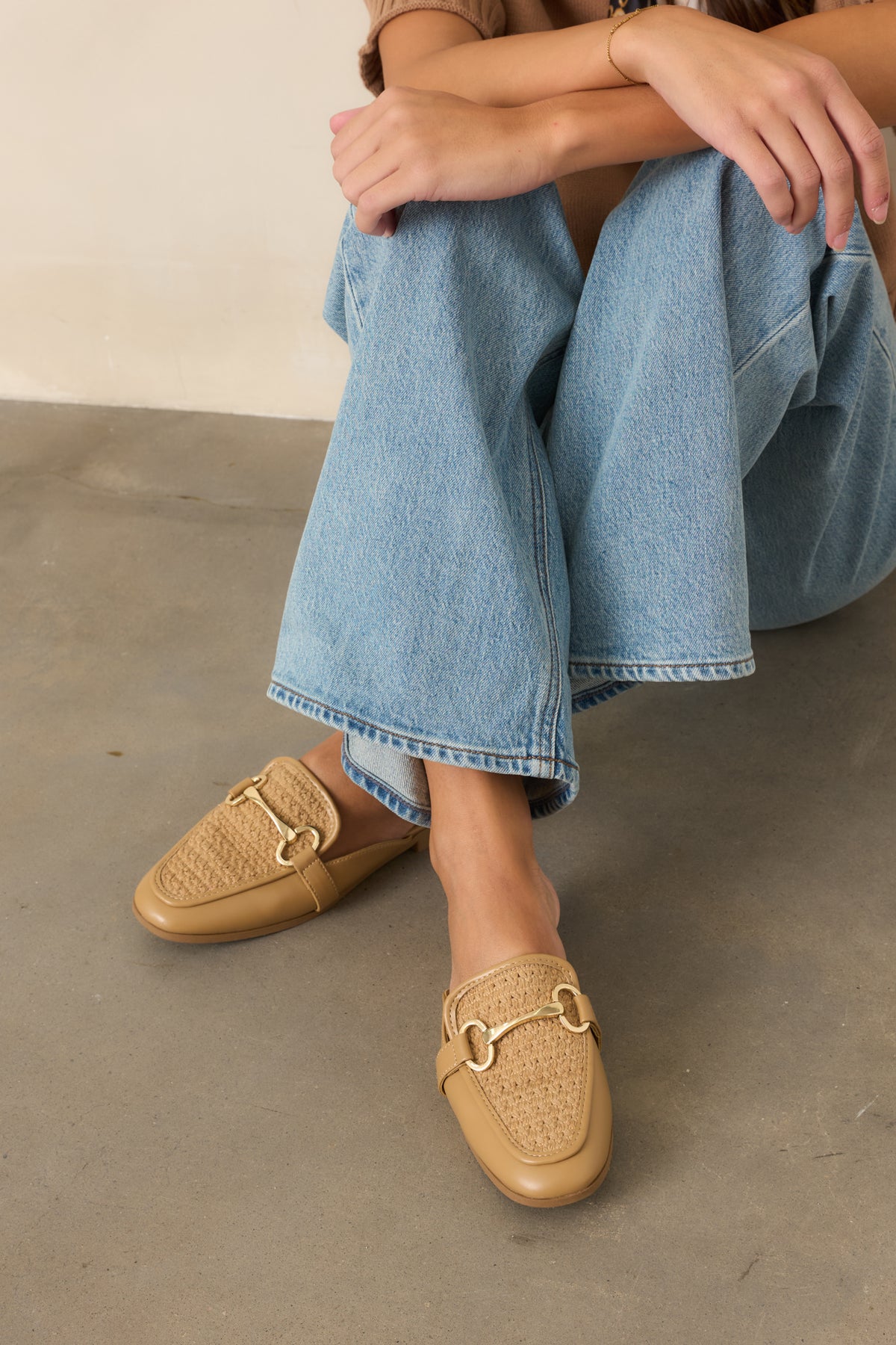 Woven mules showcasing a dimensional textured upper and polished gold-tone hardware accent.