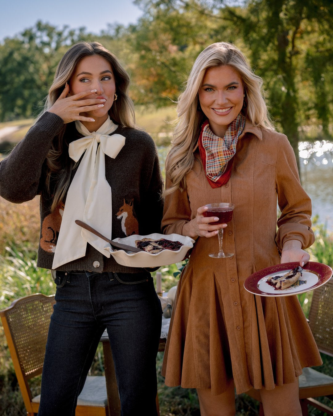 Thanksgiving outfits: a fox motif sweater with an ivory tie neck blouse and dark jeans, and a camel corduroy shirt dress with a tartan scarf, pie in hand