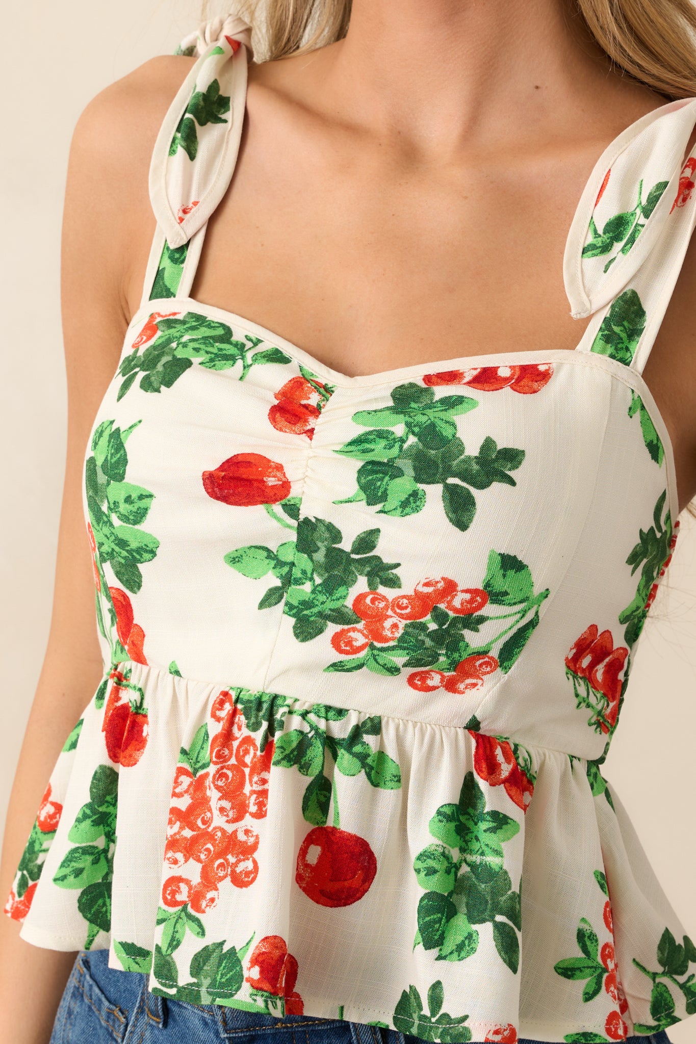 The cinched sweetheart neckline and adjustable self-tie straps add a touch of structure and comfort to this ivory top with a tomato vine print.