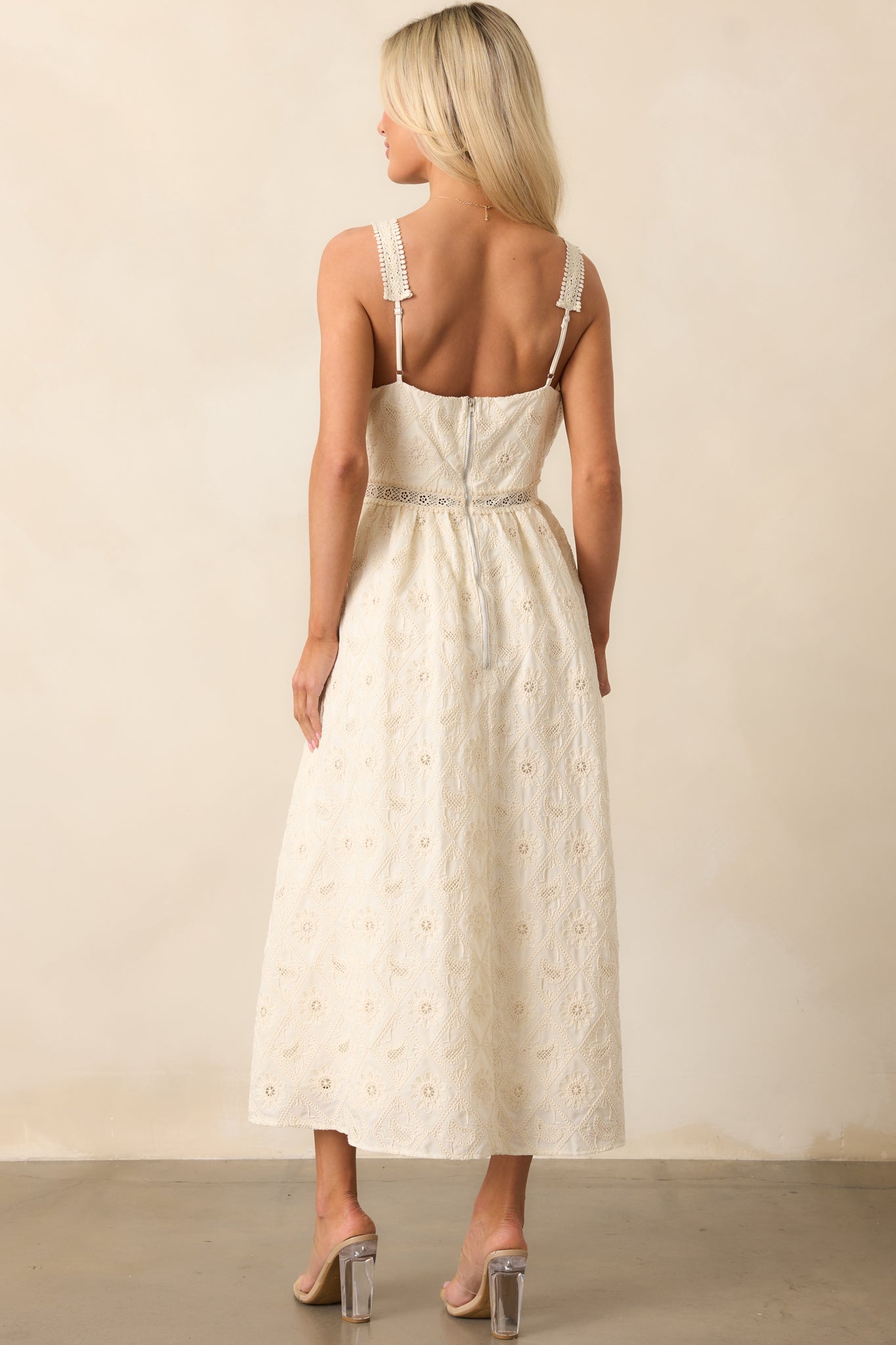 The back of the ivory dress, highlighting the adjustable straps and the overall delicate, feminine design that complements the lace embroidery and v-neckline.