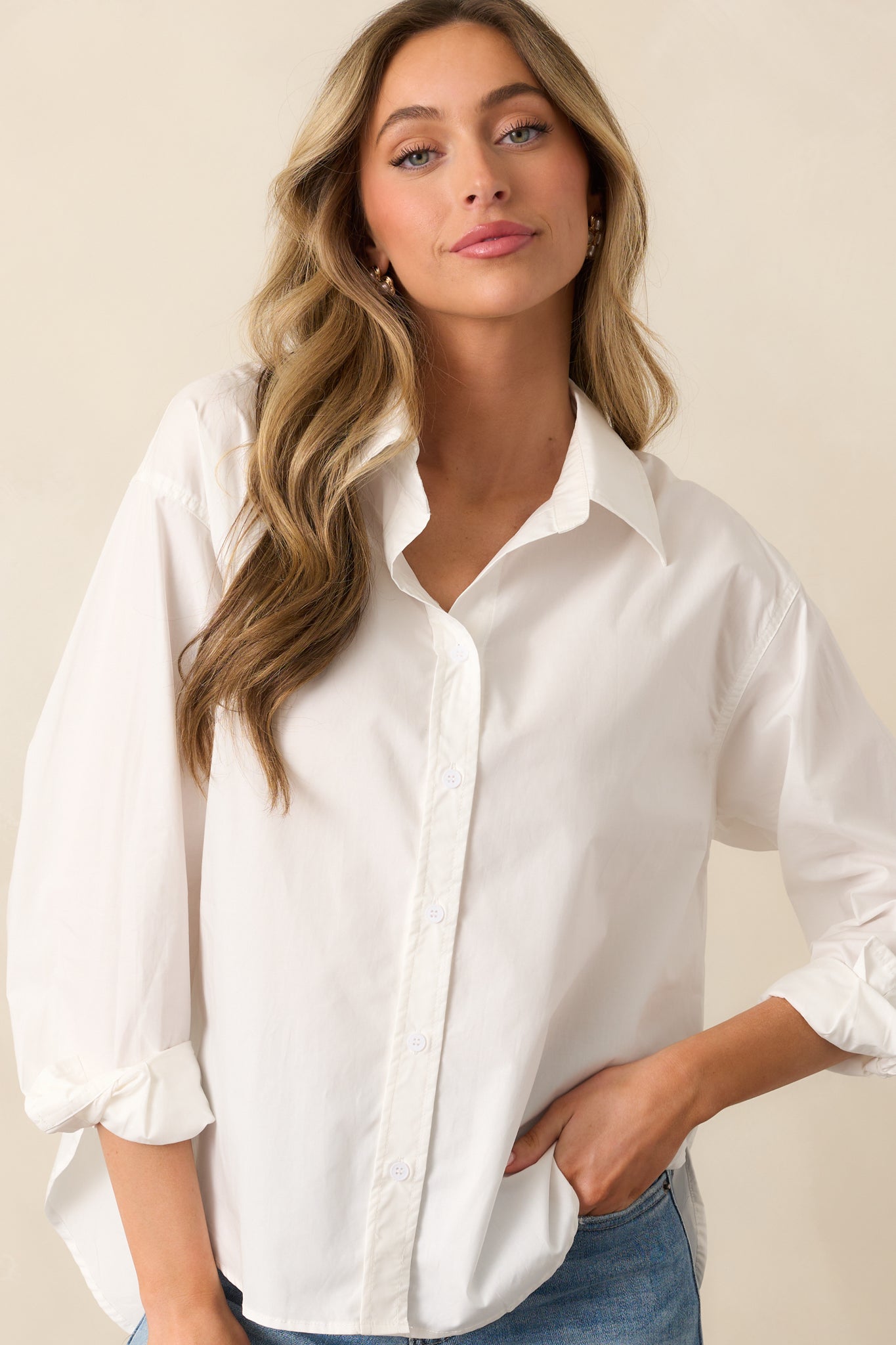 The long sleeves and buttoned cuffs add a touch of sophistication to this sleek white top.