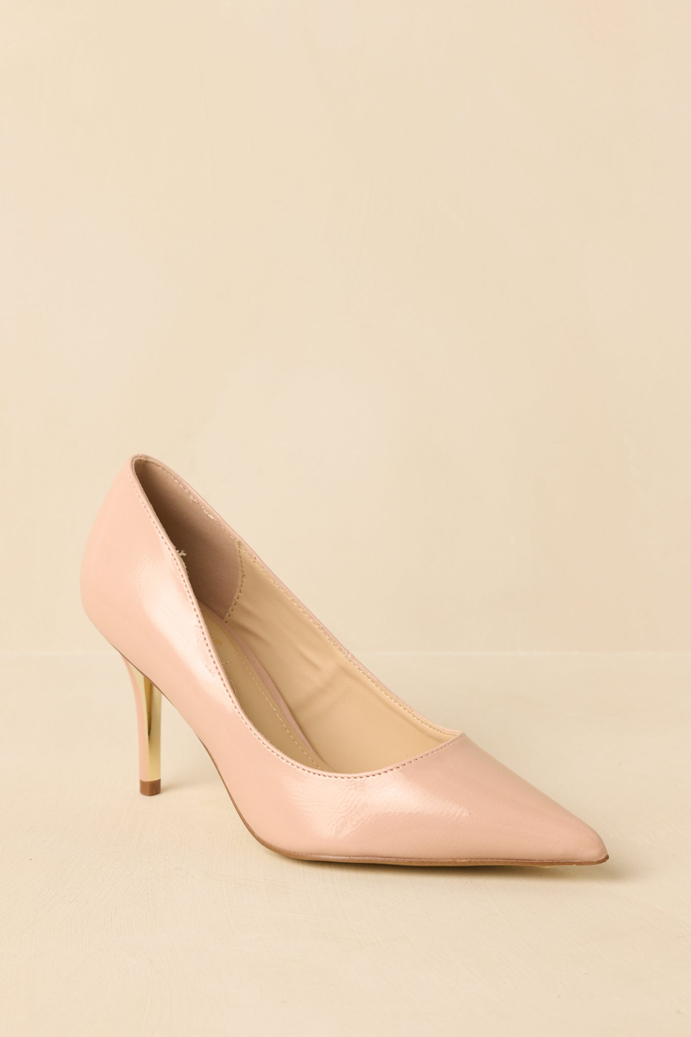Three-quarter angle view showing the refined pointed toe and smooth patent surface.