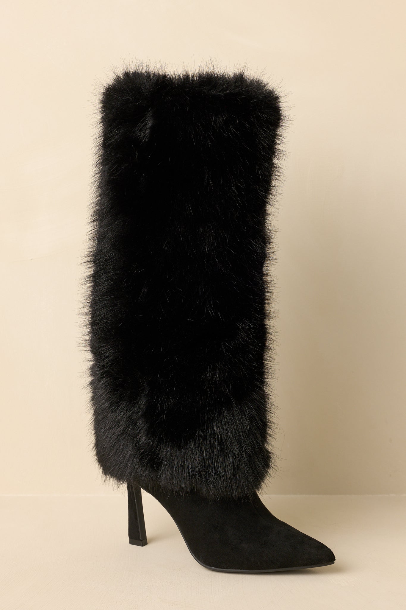 Three-quarter angle highlighting the pointed-toe shape and sleek silhouette of the boots.