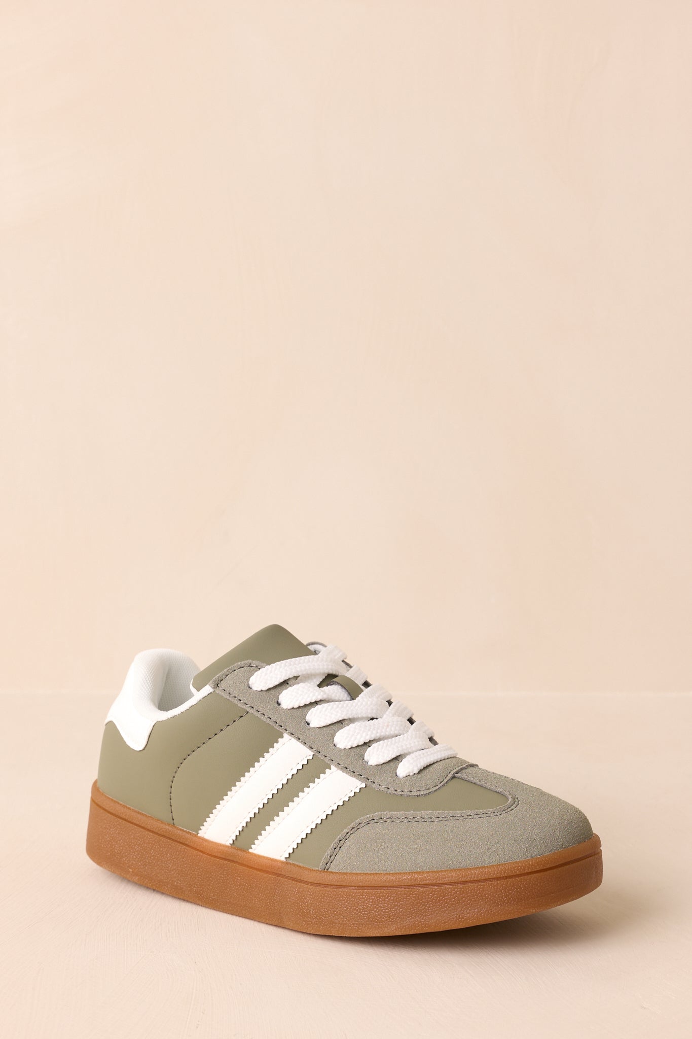 Three-quarter front angle showing the smooth synthetic panels, rounded toe shape, and white stripe detailing.