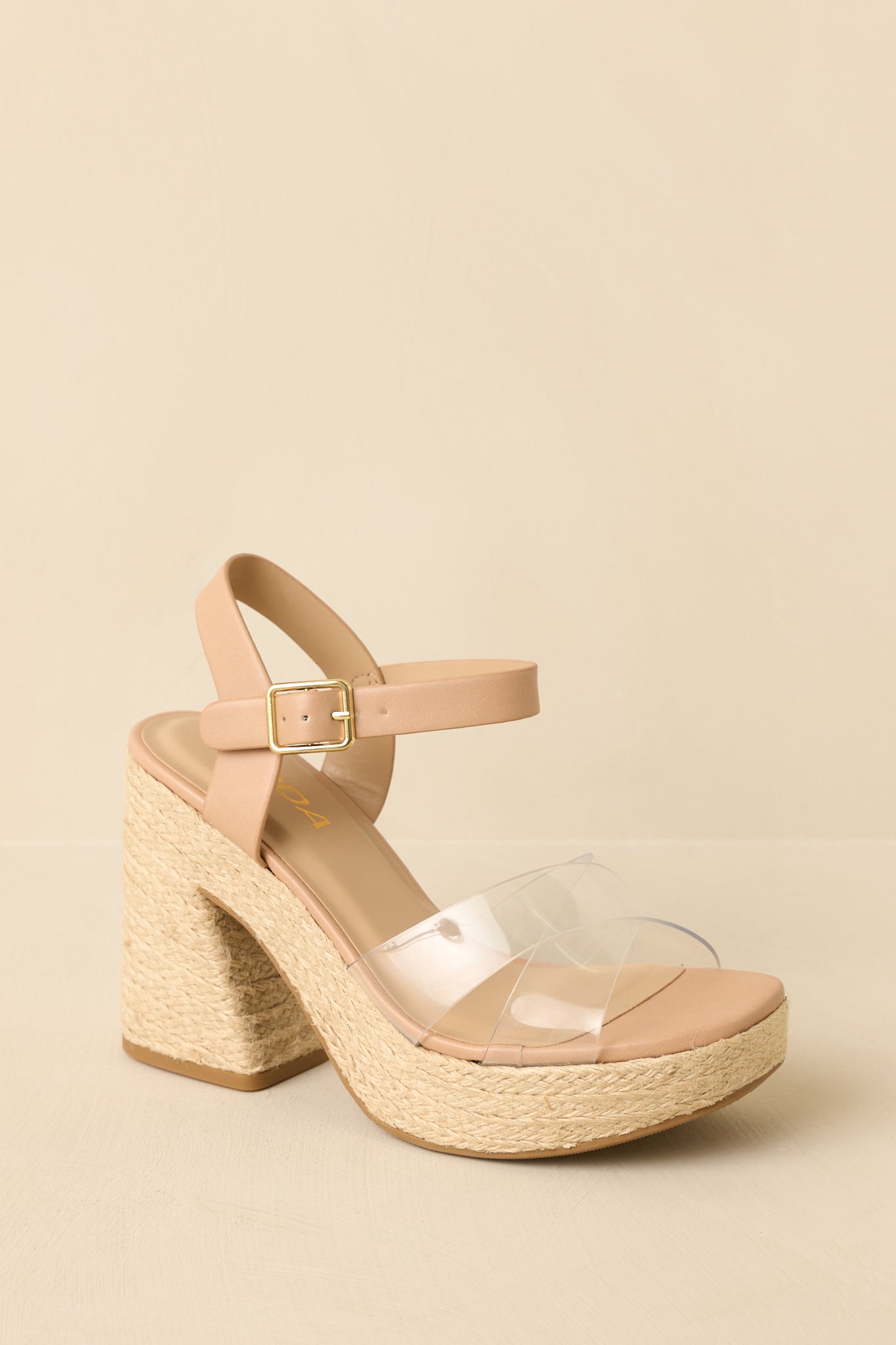 Three-quarter angle view showing the adjustable ankle buckle and stable block heel design.