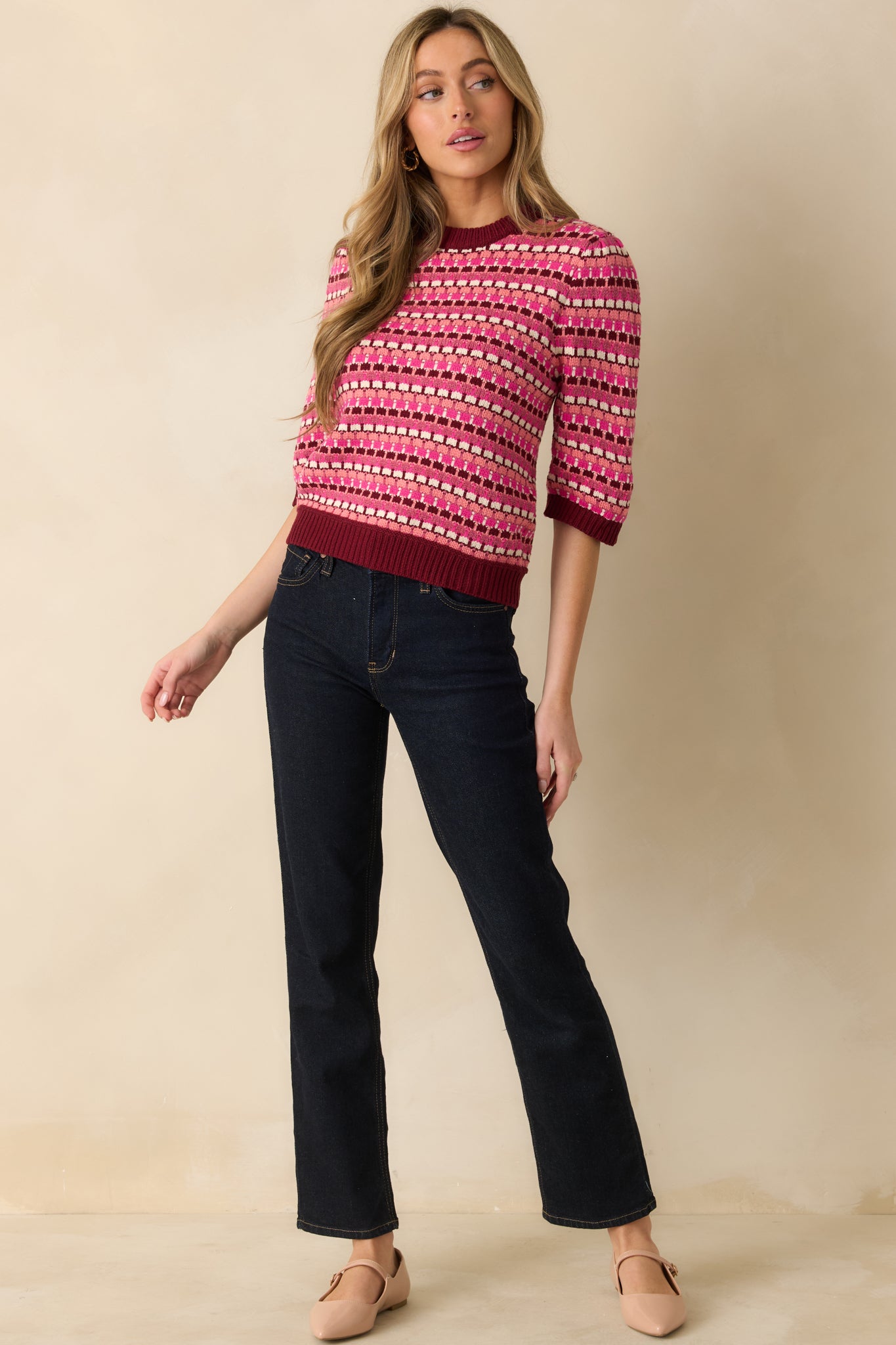 The 3/4 sleeves and ribbed hem emphasize the structured yet soft knit construction.