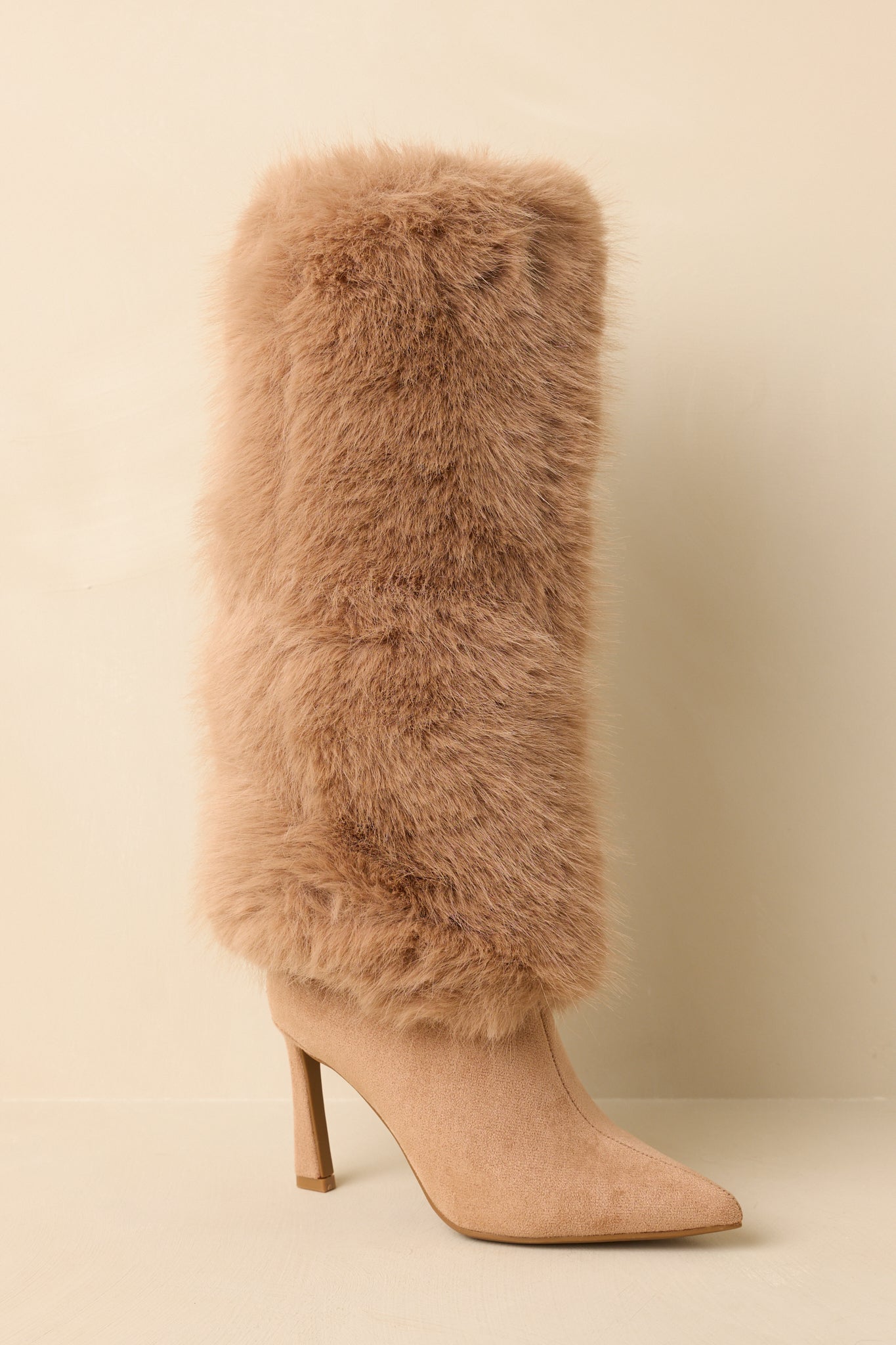 Three-quarter angle highlighting the pointed-toe shape and sleek silhouette of the tan stiletto boots.