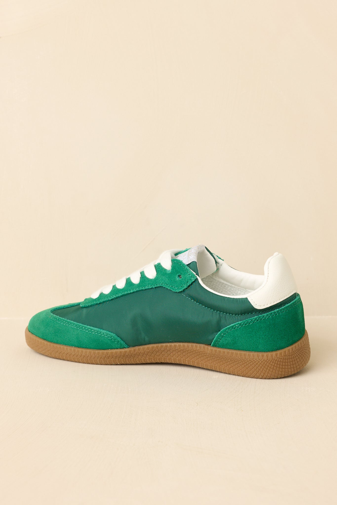 Three-quarter view emphasizing the layered finish of suede and synthetic panels with a classic low-top silhouette.