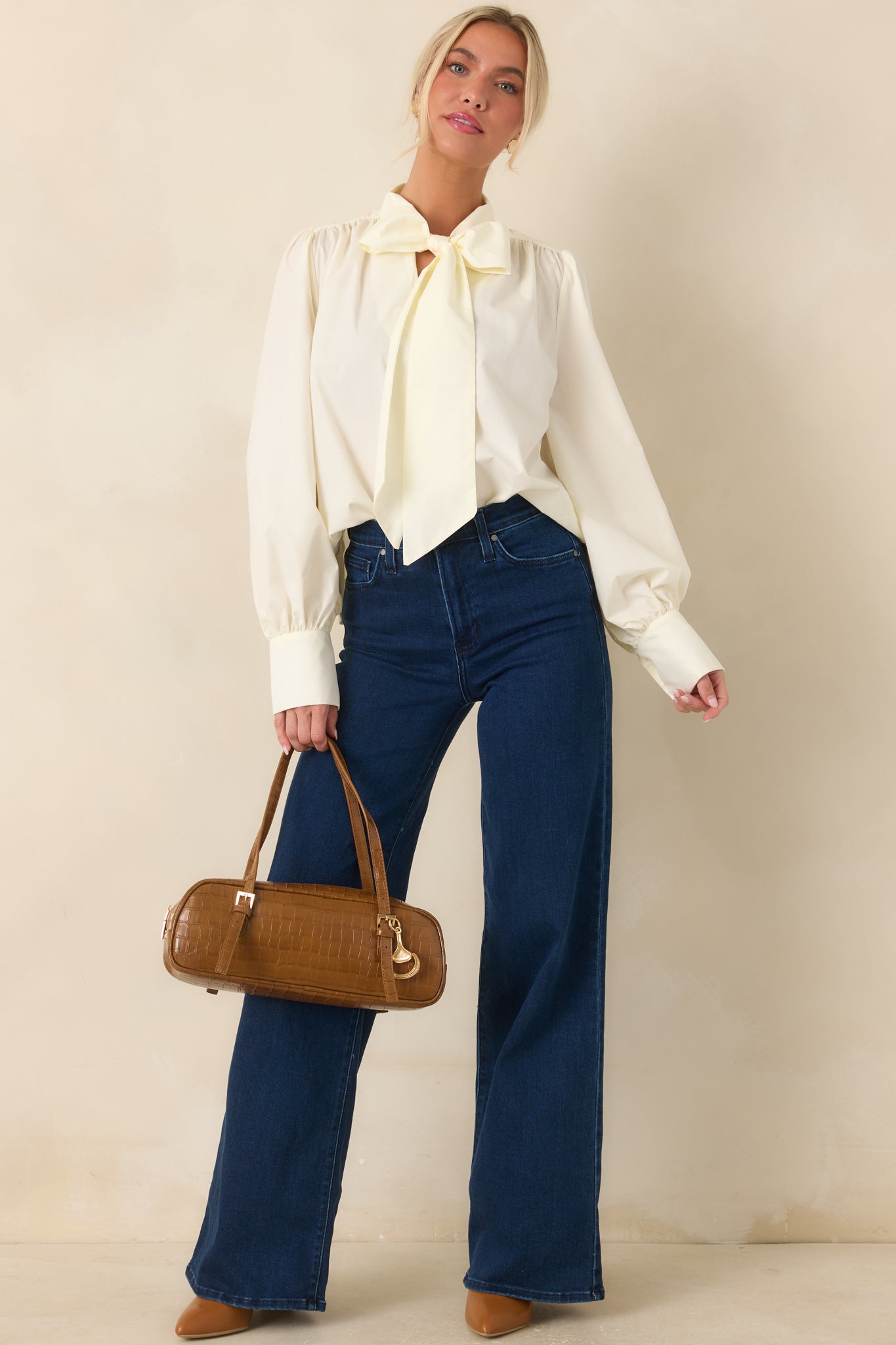 Polyester-cotton blend blouse featuring a statement tie neckline, softly gathered shoulders, long balloon sleeves, and wide button cuffs.