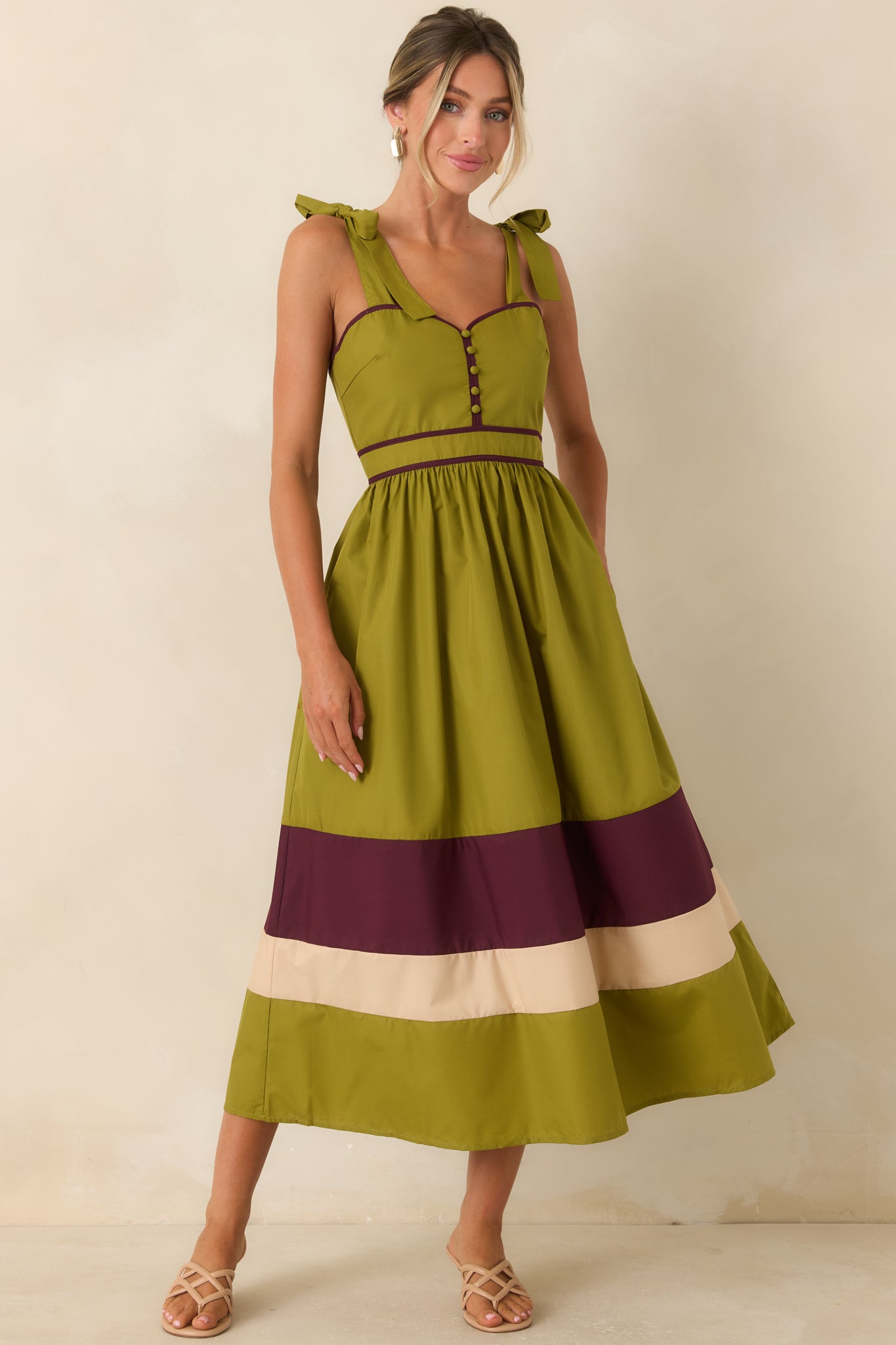 Feminine midi dress showcasing adjustable tie straps, a smocked back, hidden pockets, and a flowing gathered skirt.