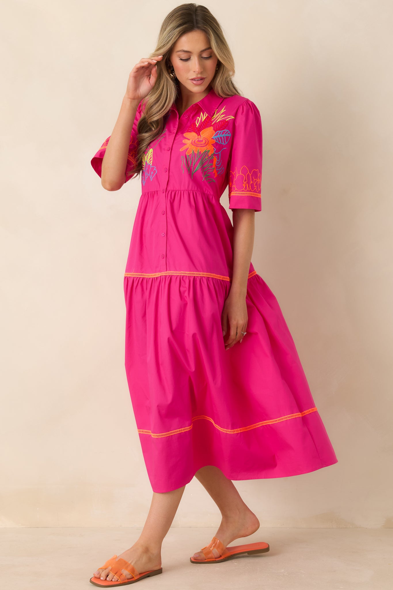 Tiered dress with structured collar, button-front closure, and relaxed movement.