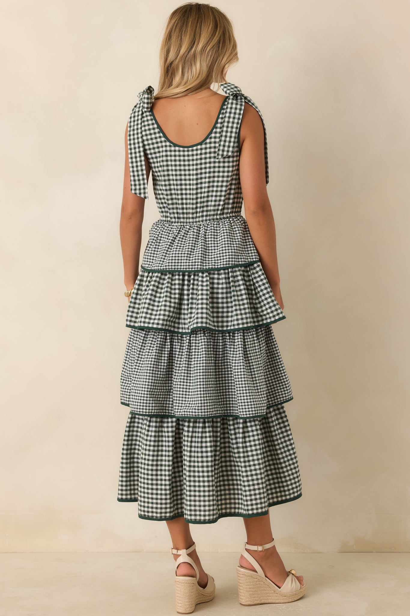 Rear view of the tiered dress featuring fixed shoulder ties, smocked bodice, and flowing layered skirt.