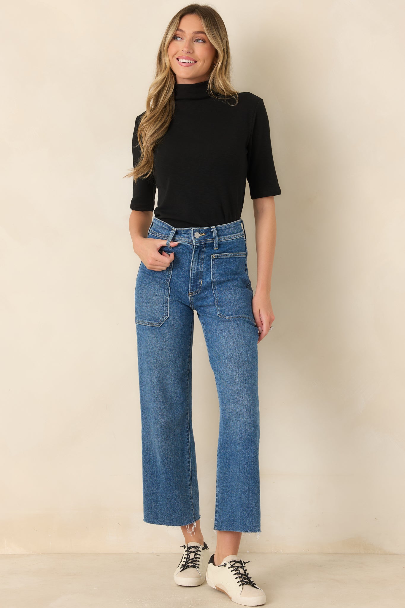 Timeless black mock neck top with a smooth knit texture, comfortable stretch fabric, elbow sleeves, and a versatile fitted design.