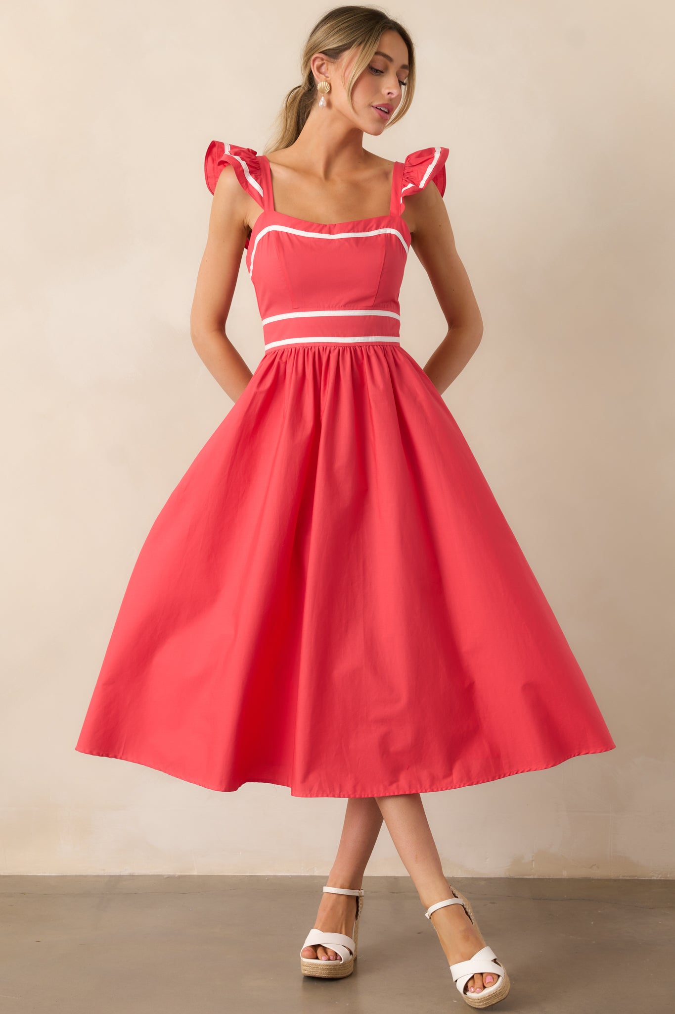 A chic tomato red dress with contrast white hem detailing, fluttery sleeves, and a polished, effortless design.