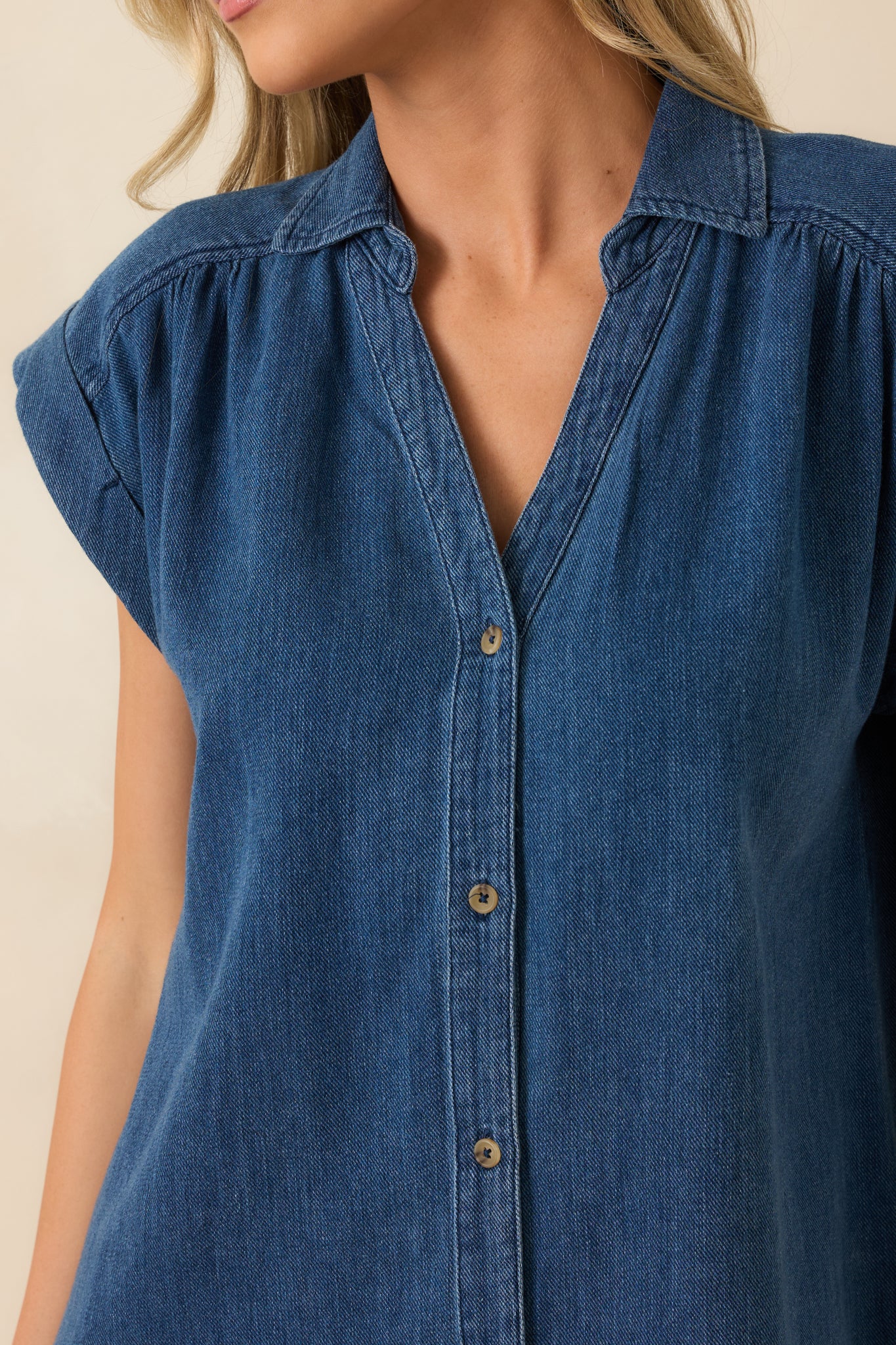 Close-up of the tonal buttons, camp collar, and textured indigo twill fabric.
