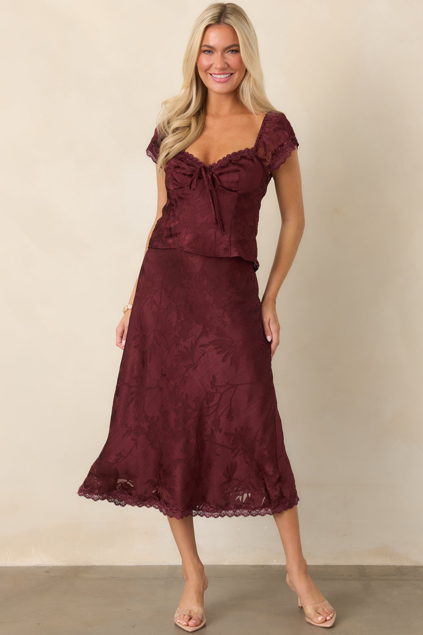 Tonal floral satin midi skirt featuring a fluid bias-cut silhouette, elegant drape, and delicate lace trim along the hem.