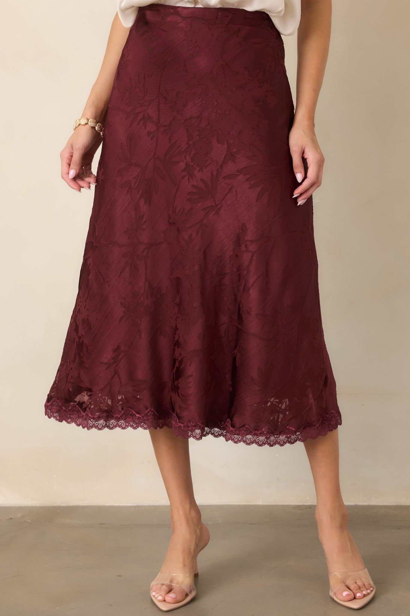 Satin skirt detail highlighting the tonal floral pattern, smooth bias-cut fabric, and softly flowing silhouette.