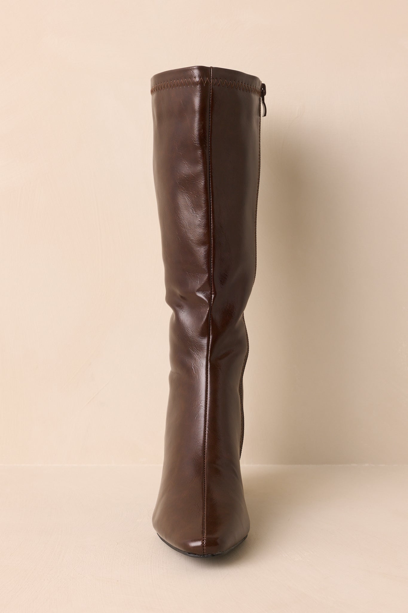 Top-down view of brown boots emphasizing pointed toe and tonal stitching.