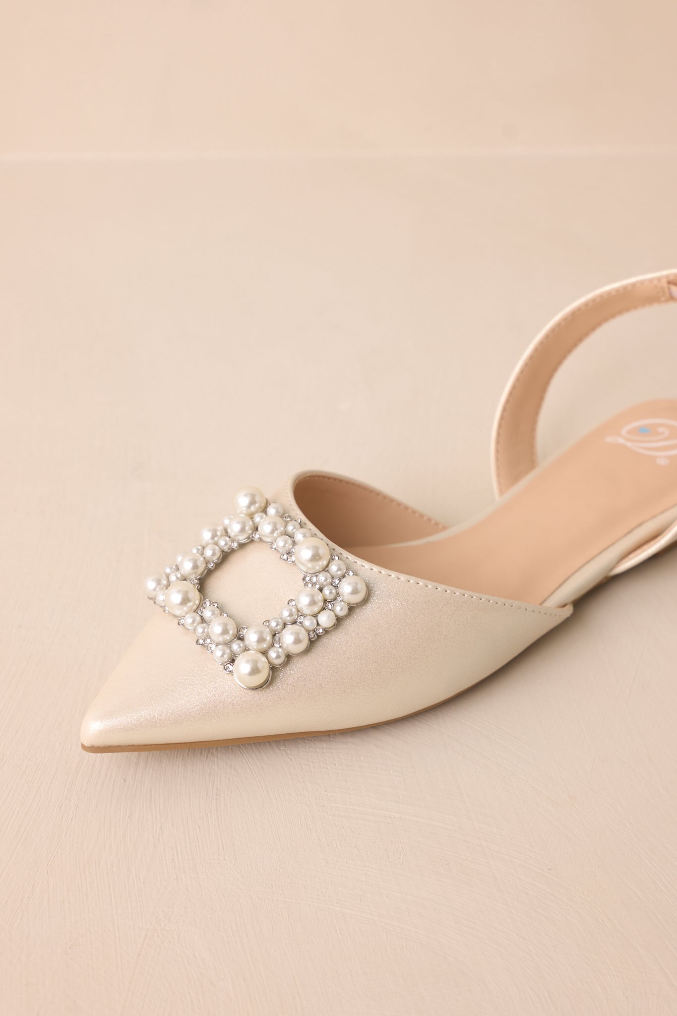 Full top-down view of the flats, highlighting the large rhinestone square buckle and the various-shaped ivory faux pearls and rhinestones adorning it.