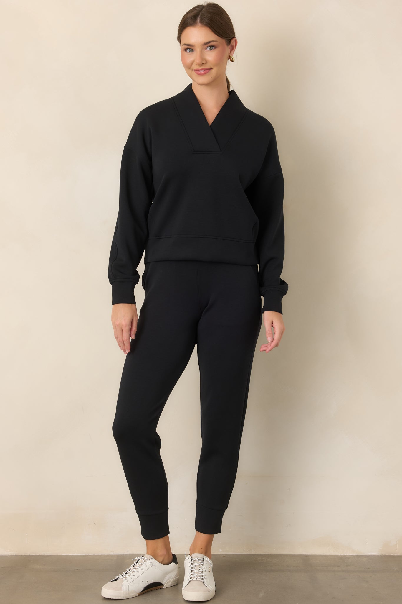 Polished top with a defined V-neckline, broad collar, relaxed dropped shoulders, and long cuffed sleeves.
