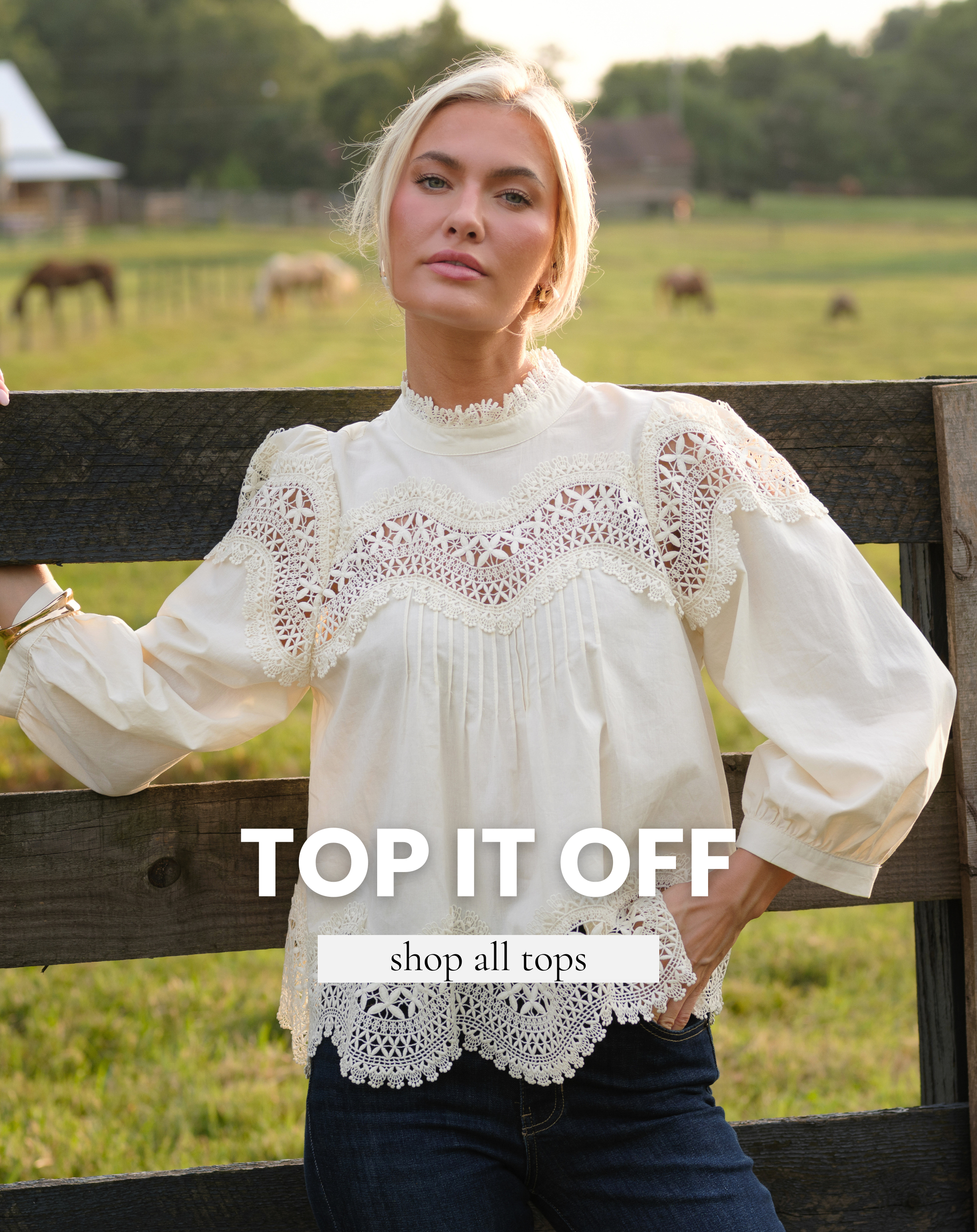 Model wearing a white blouse and denim pants. Text reads "Top It Off" and "Shop All Tops."