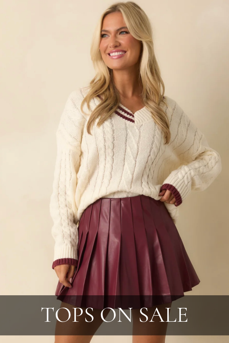 Model wearing a white knit sweater and red leather skirt. Tops On Sale.