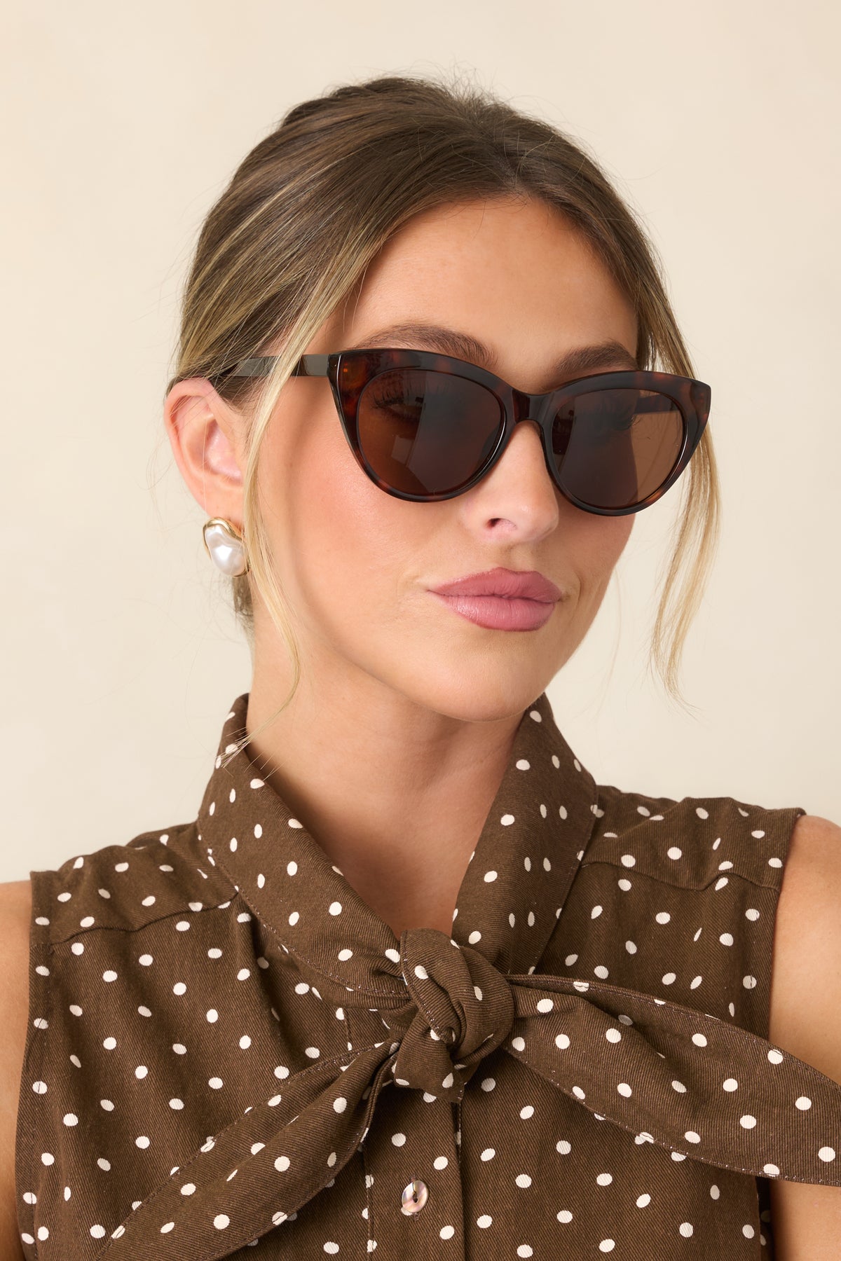 Vintage-inspired tortoise sunglasses showcasing their curved cat-eye silhouette, polished brown frame, and softly tinted lenses.