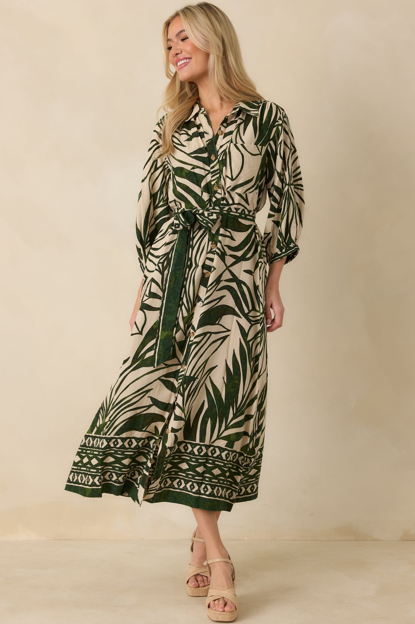 Front view of tropical print maxi dress featuring optional self-tie belt, elastic cuffs, and single breast pocket.