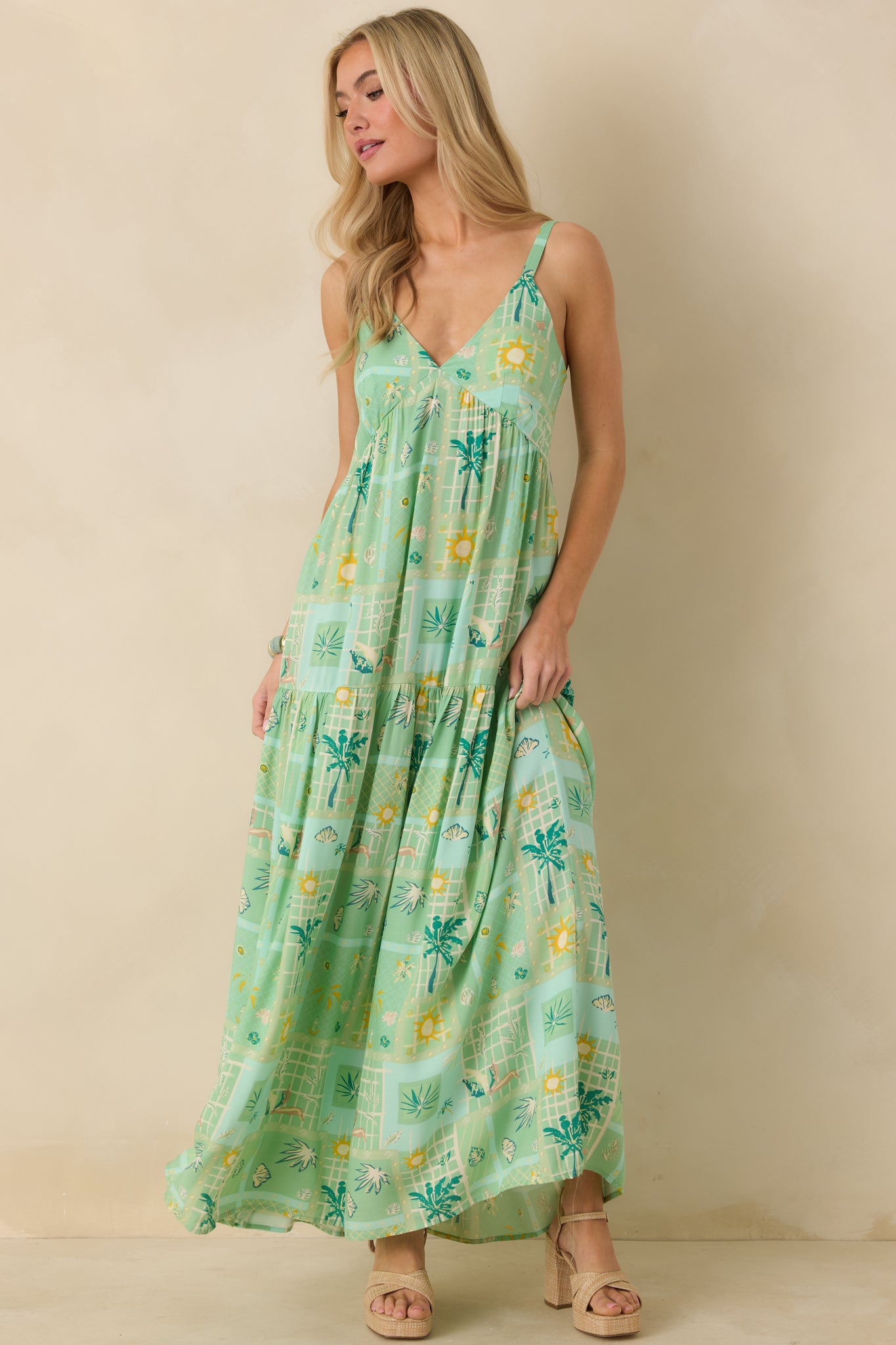 Tropical print sleeveless maxi dress featuring a flattering V-neck and flowing tiered silhouette.
