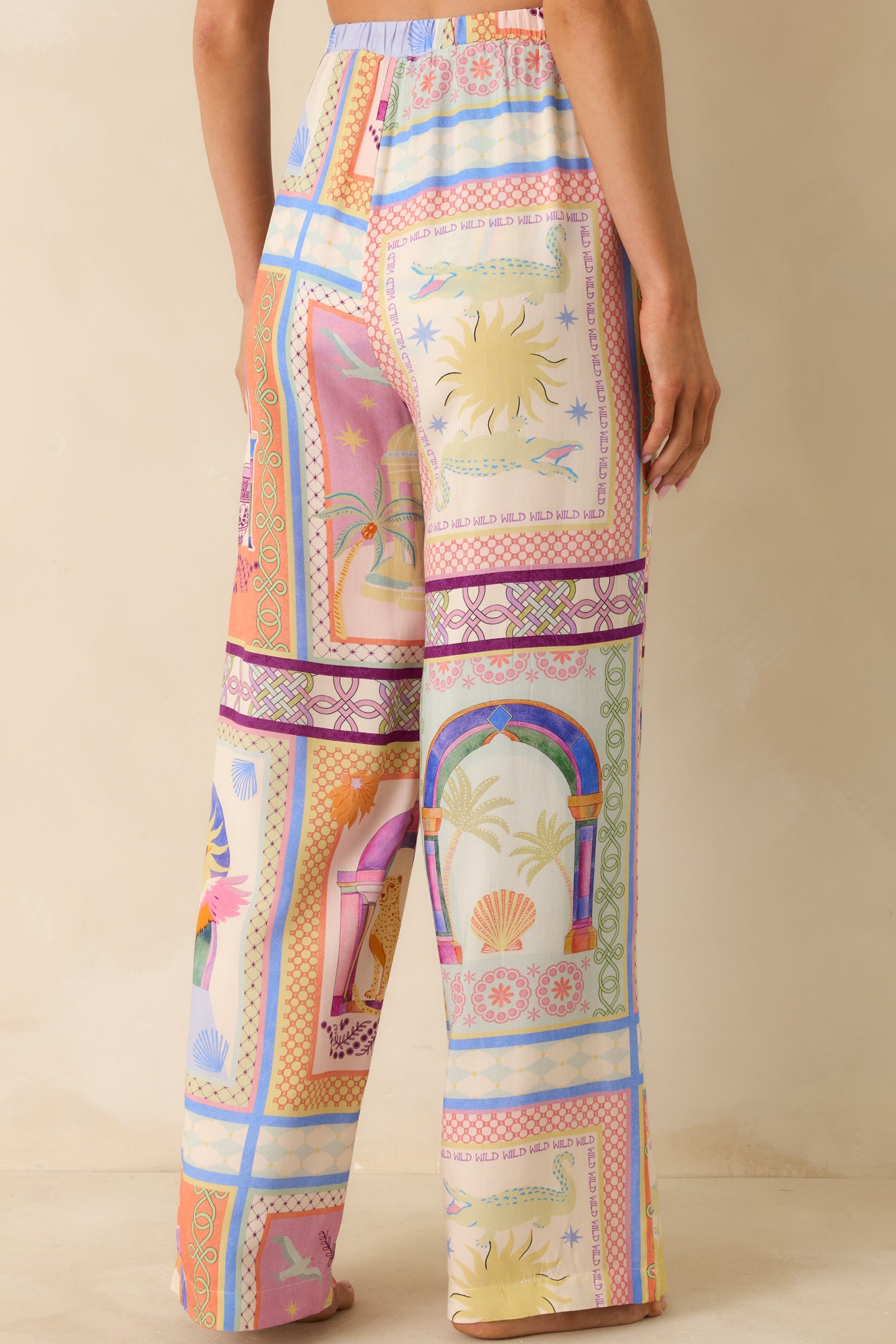Back view of the tropical print pants highlighting the relaxed wide legs and flowing full-length silhouette.