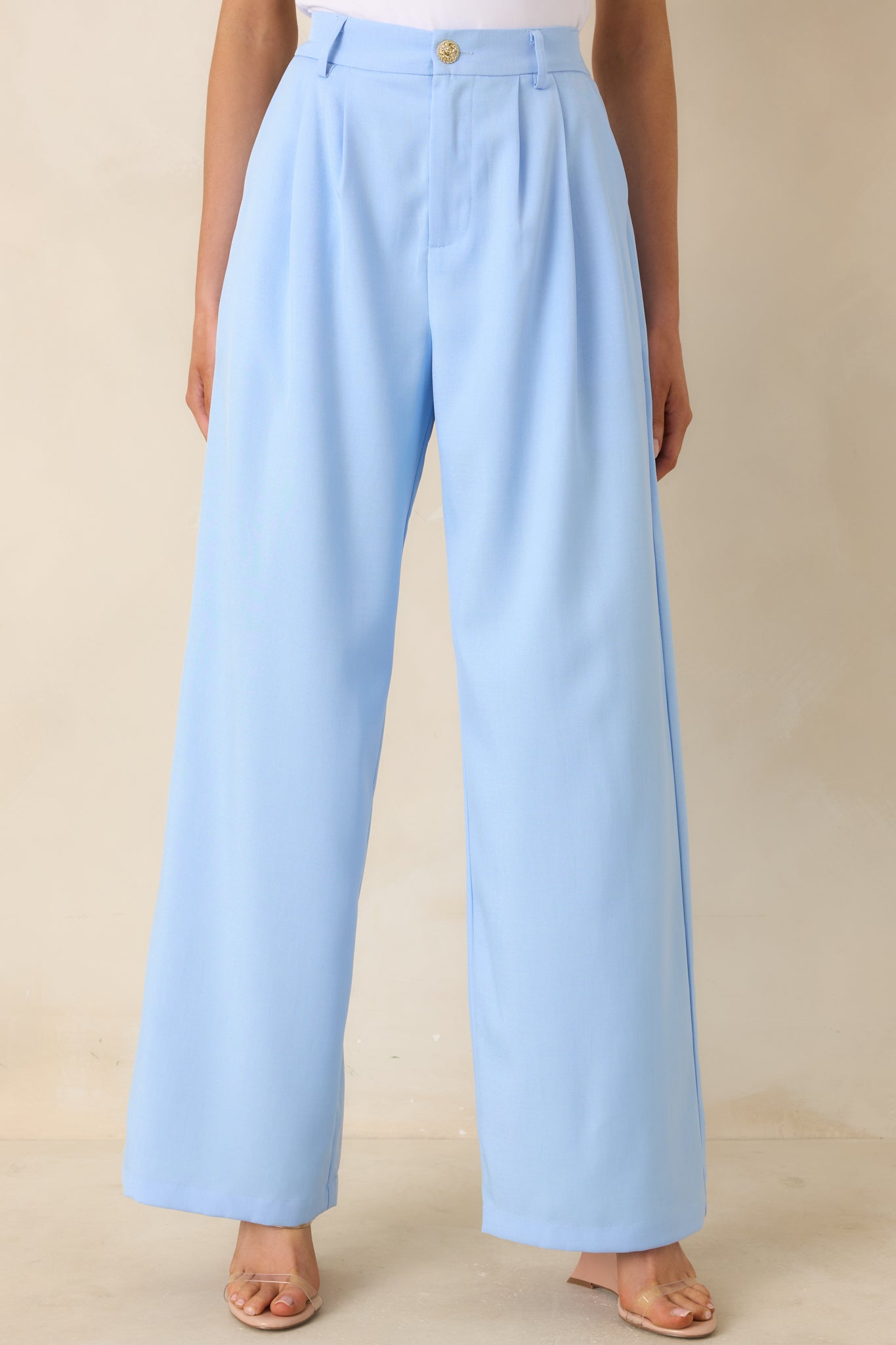 Trousers highlighting structured silhouette and soft pleating detail.