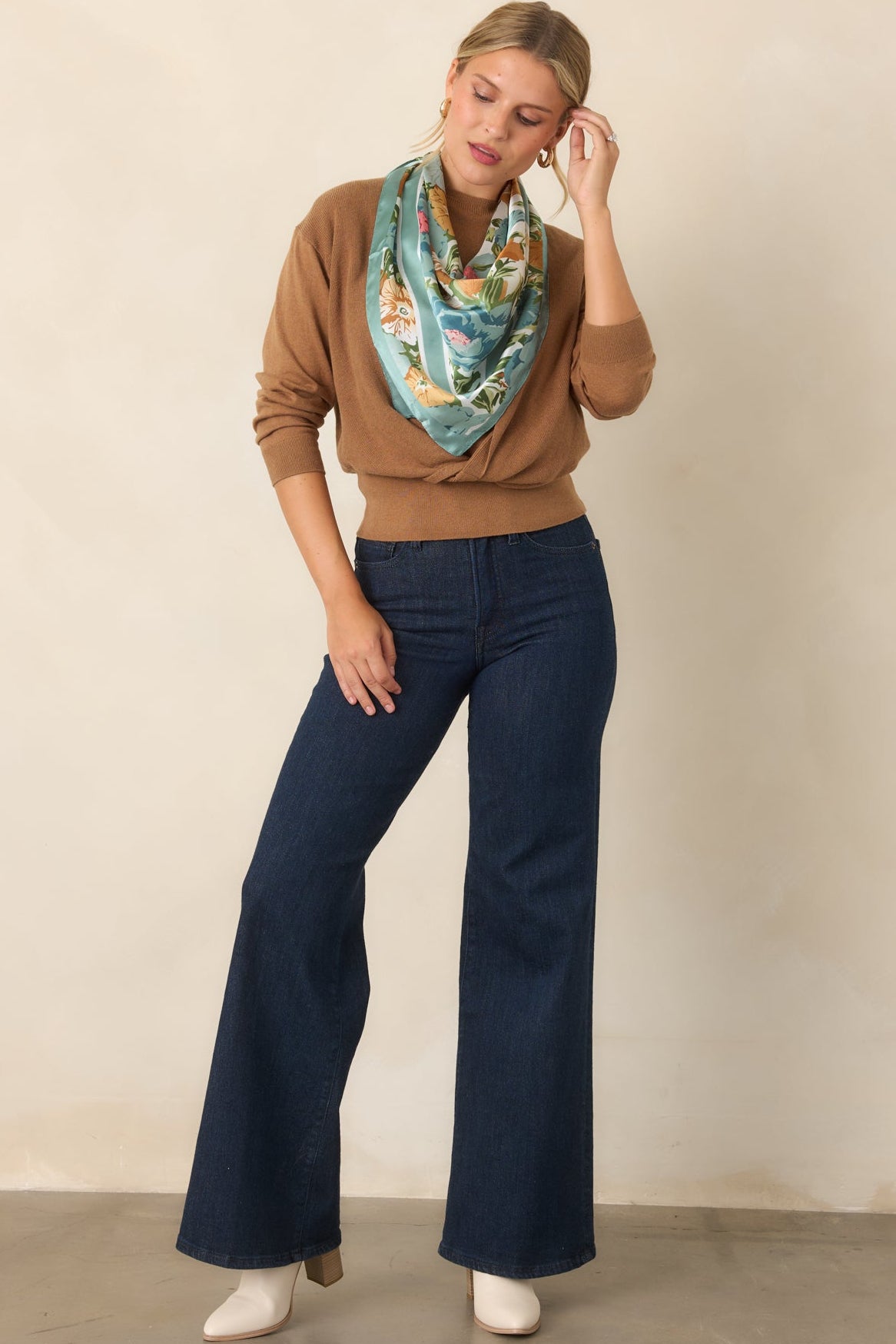 Two-layer sweater top featuring a twisted front design and wide ribbed hem defining the waist.